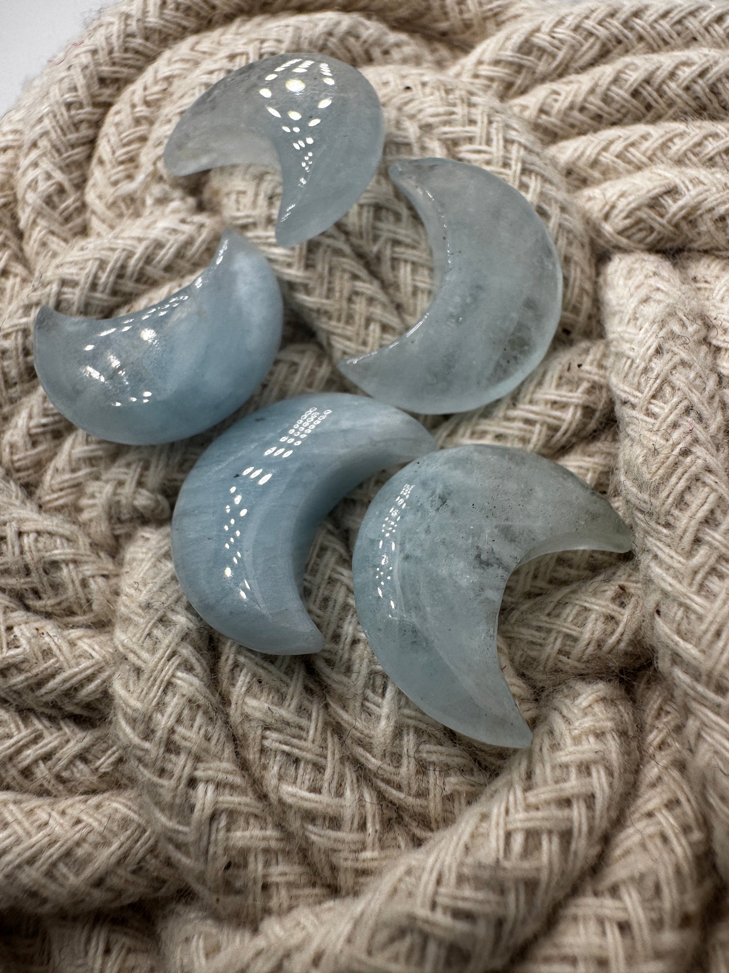 Handgefertigtes Carving aus Aquamarin in Mondform, helles eisenblaues Beryll-Mineral mit natürlicher Transparenz.