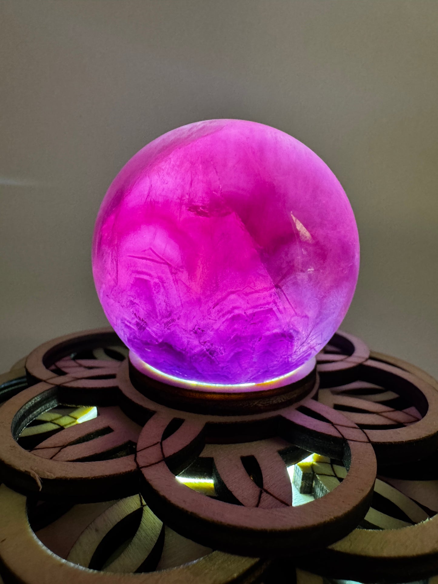 Fluorit-Kugel mit natürlichem Rosa-Grün-Farbverlauf und feiner Zonierung auf einem Leuchtsockel.
