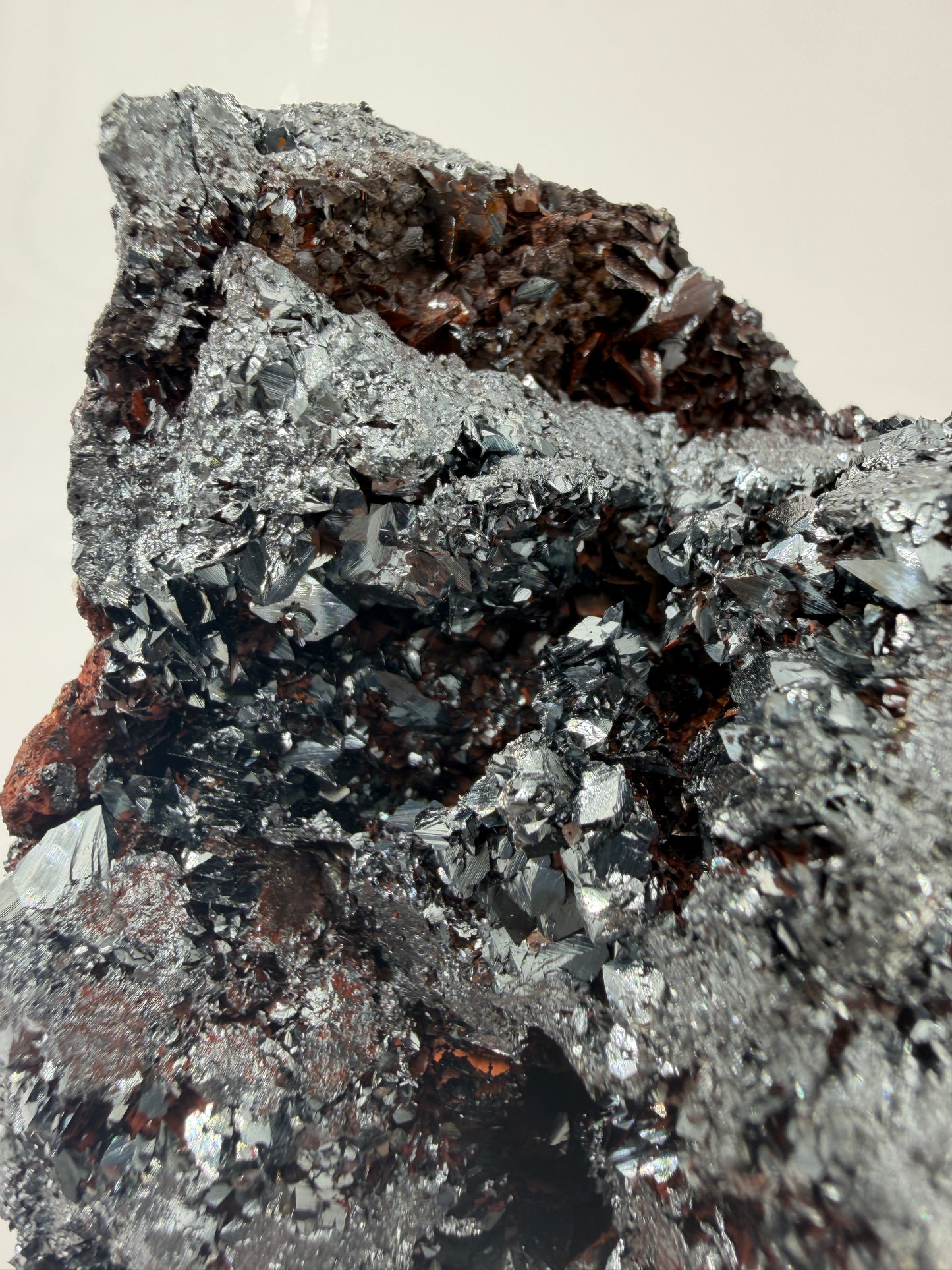Nahaufnahme der Kristallflächen eines Elba-Hämatits, zeigt den Spiegelglanz und die feine Lamellenstruktur des Minerals.