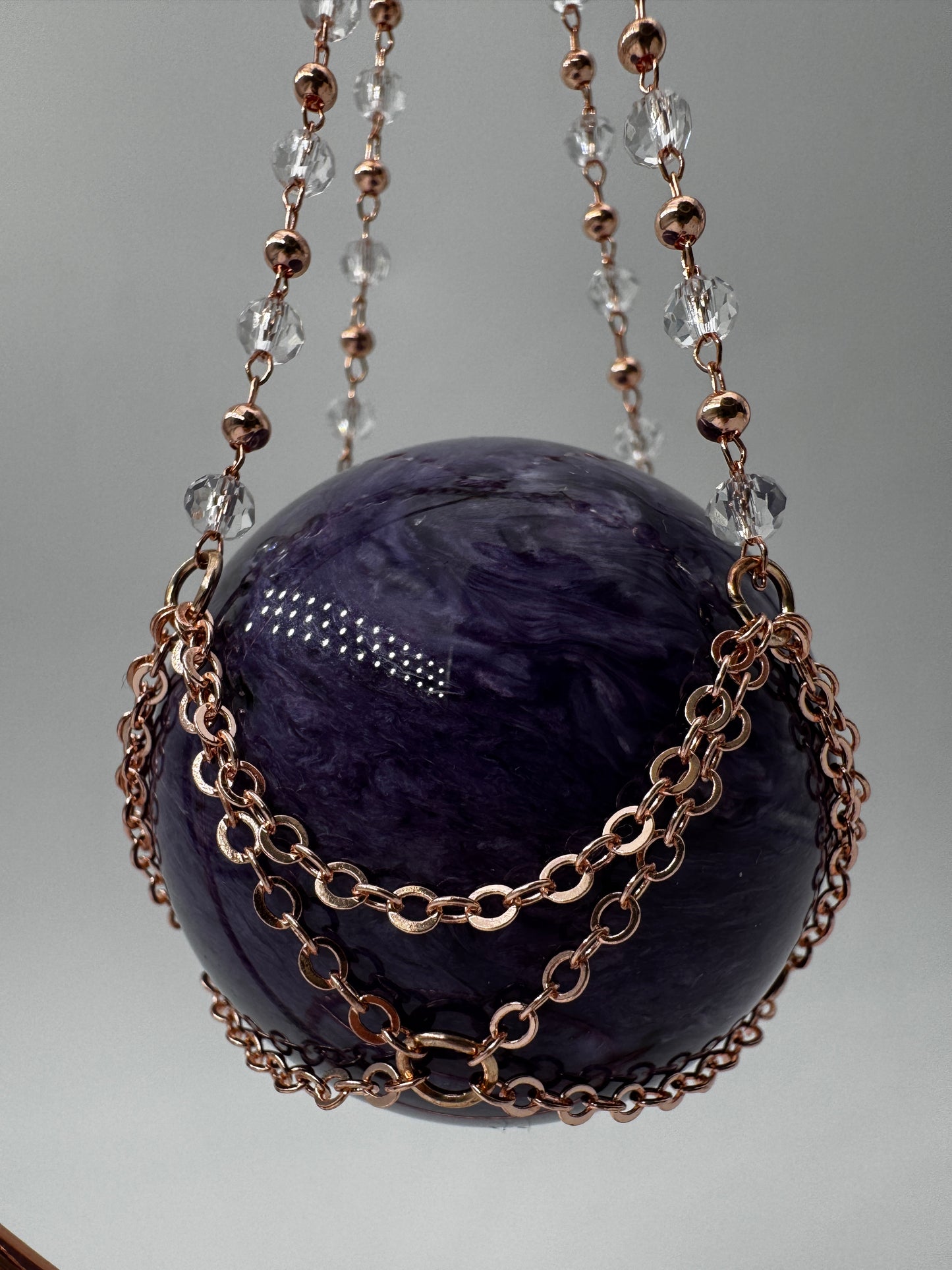 Roséfarbener Metallständer für Mineralkugeln, Höhe 23,5 cm, mit einer Beispielkugel von 4,7 cm Durchmesser.