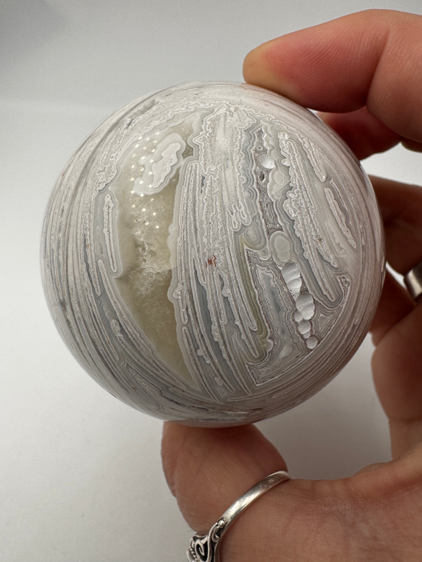 Große Kugel aus Lace Achat, Ø 6,5 cm – zarte wellenförmige Bänderung in Weiß, polierte Oberfläche.
