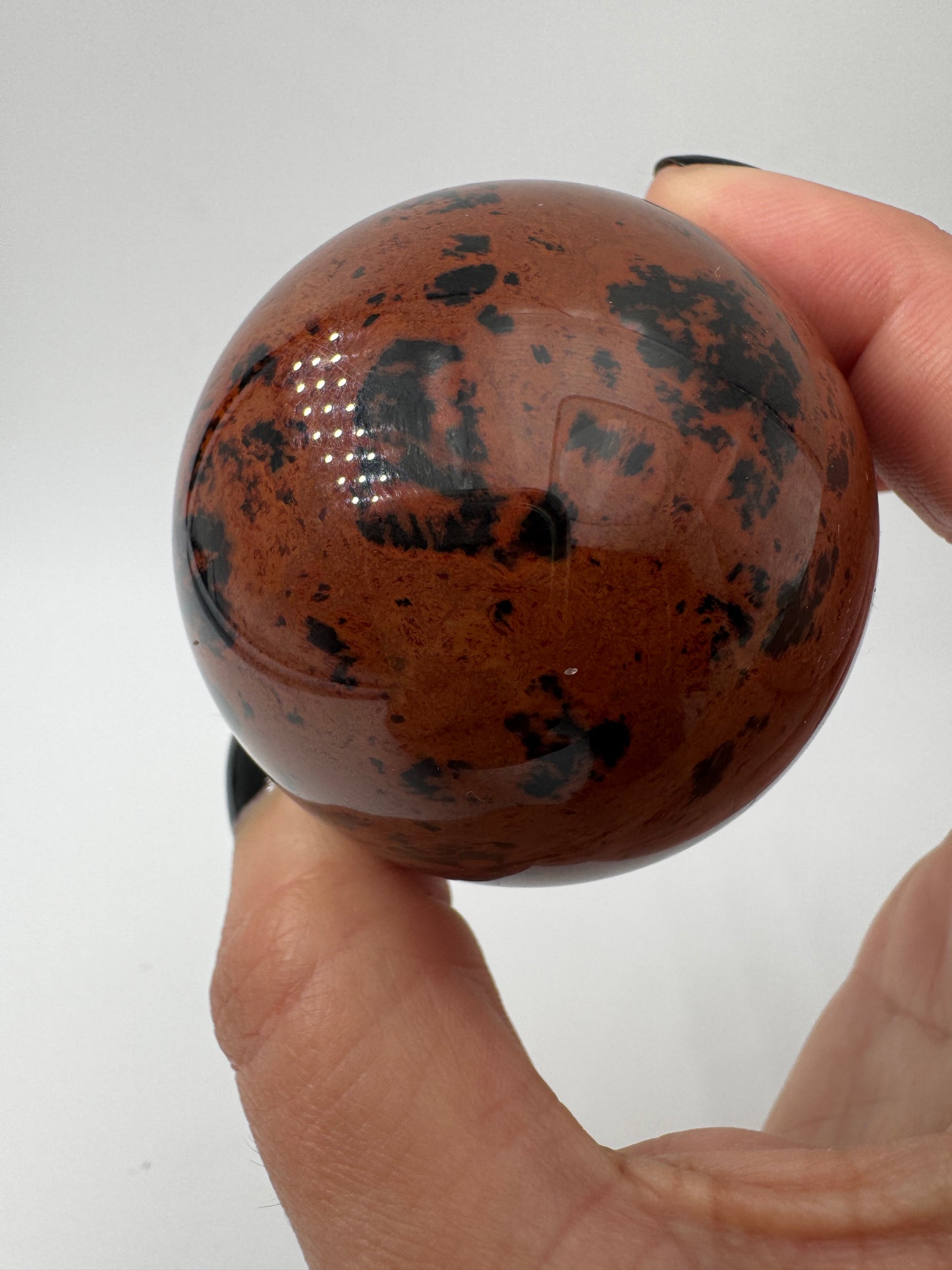 Polierte Kugel aus Mahagoni Obsidian mit rotbraun-schwarzer Maserung, Durchmesser 5,3 cm.