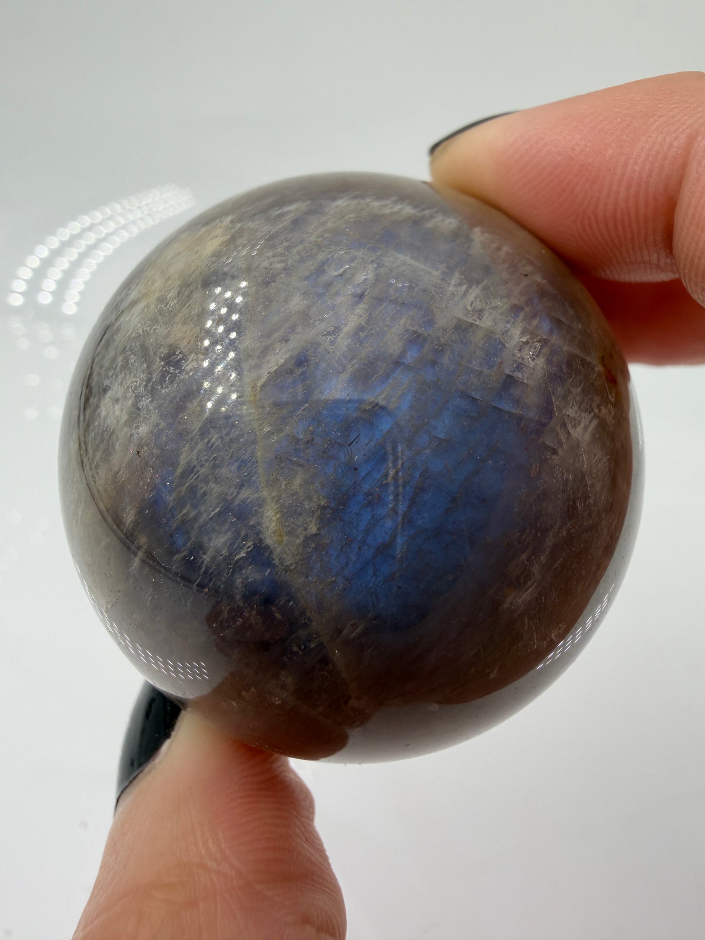 Sphärisch geschliffene dunkle Mondstein Kugel mit ausgeprägtem blauen Flächenschiller (Adulareszenz) auf anthrazitfarbener Feldspat-Matrix, professionelle Sammlerqualität