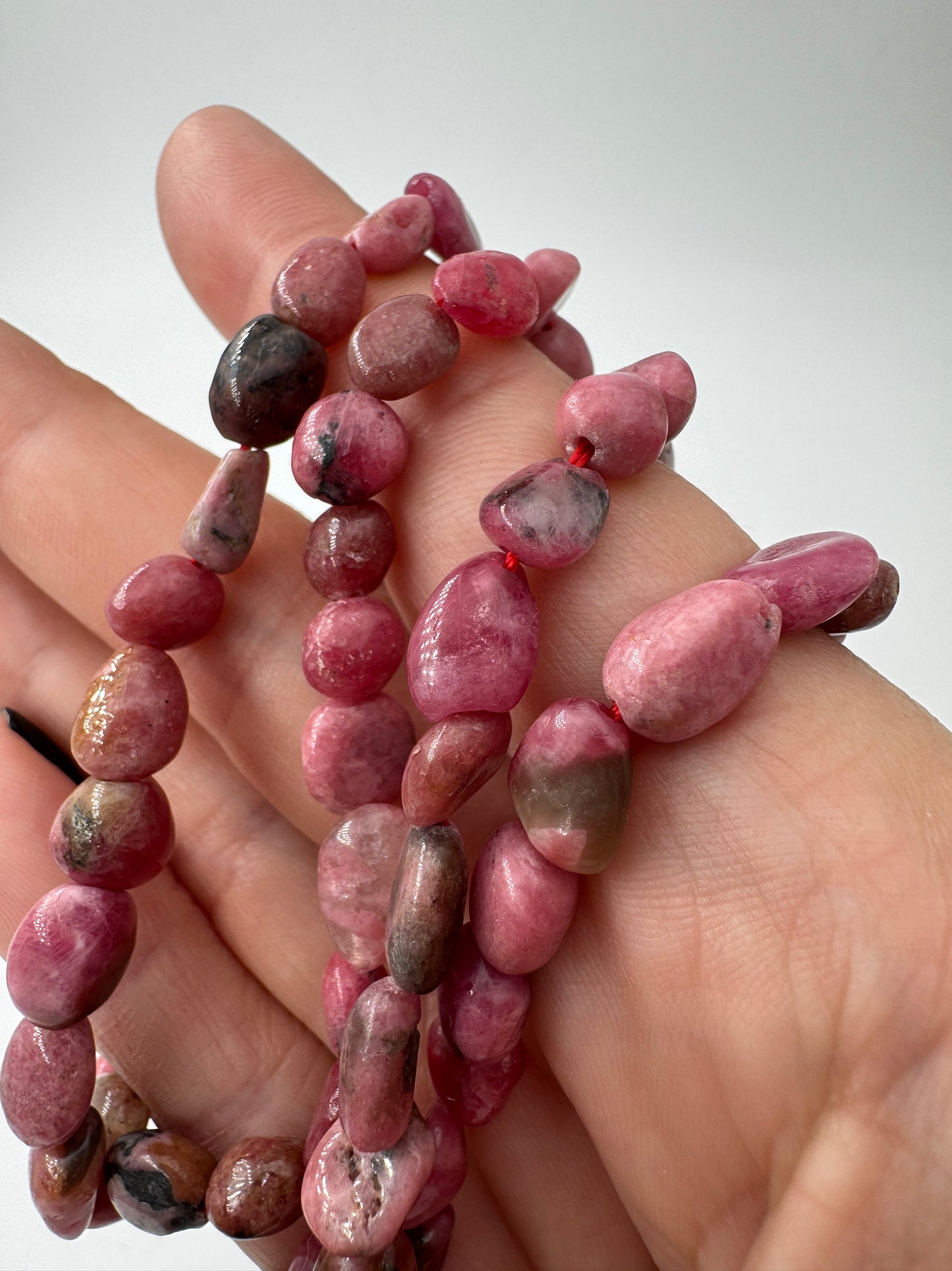 Rhodonit-Kette mit rosa Stein und schwarzen Manganoxid-Adern.