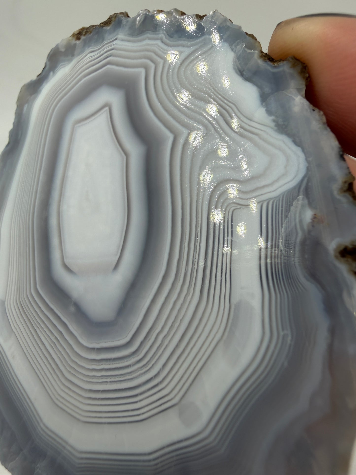 Nahaufnahme der Chalcedon-Bänderung eines marokkanischen Achats, zeigt mikro-kristalline Zuwachszonen und Quarz-Zentrum.
