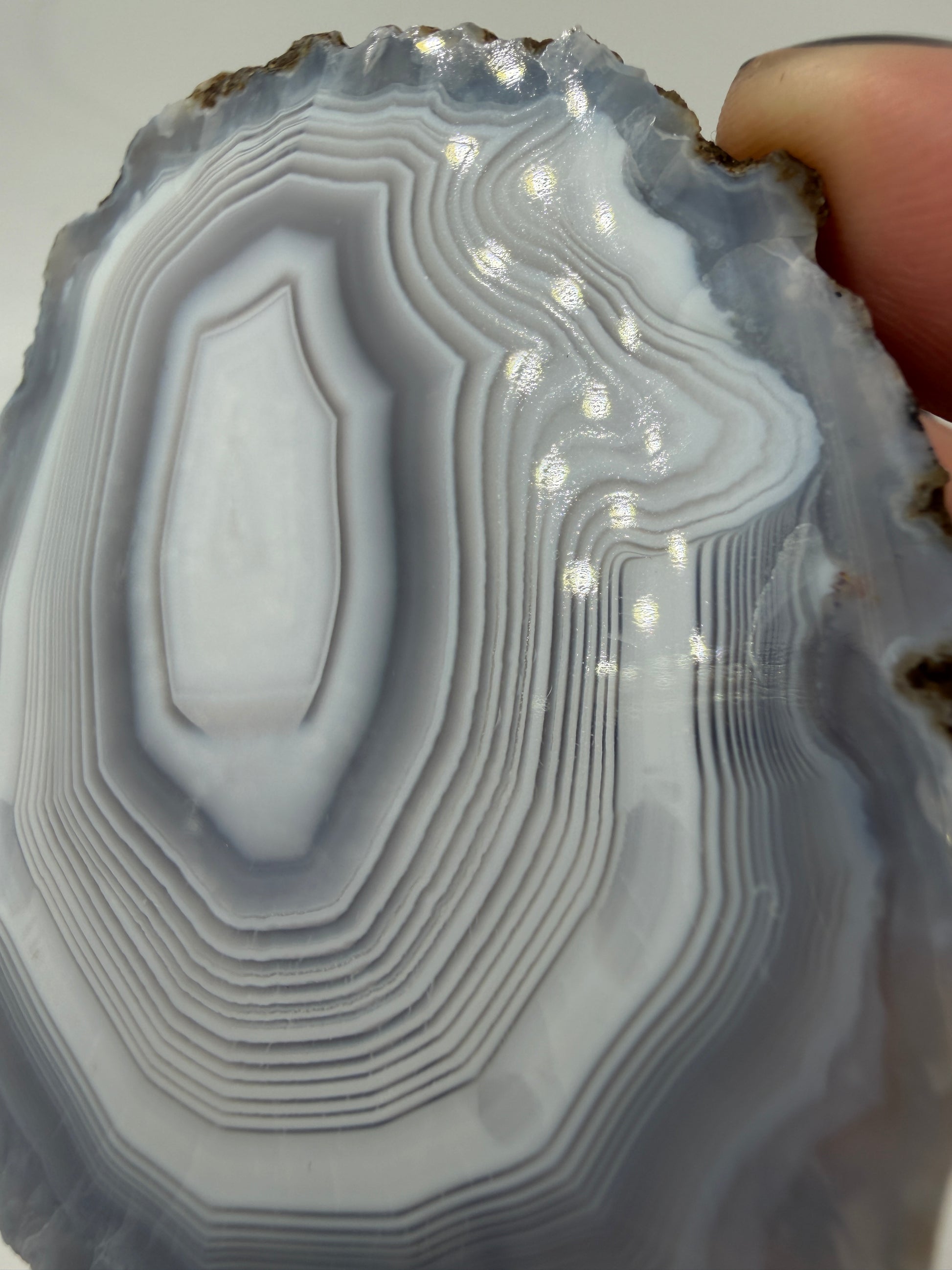 Nahaufnahme der Chalcedon-Bänderung eines marokkanischen Achats, zeigt mikro-kristalline Zuwachszonen und Quarz-Zentrum.