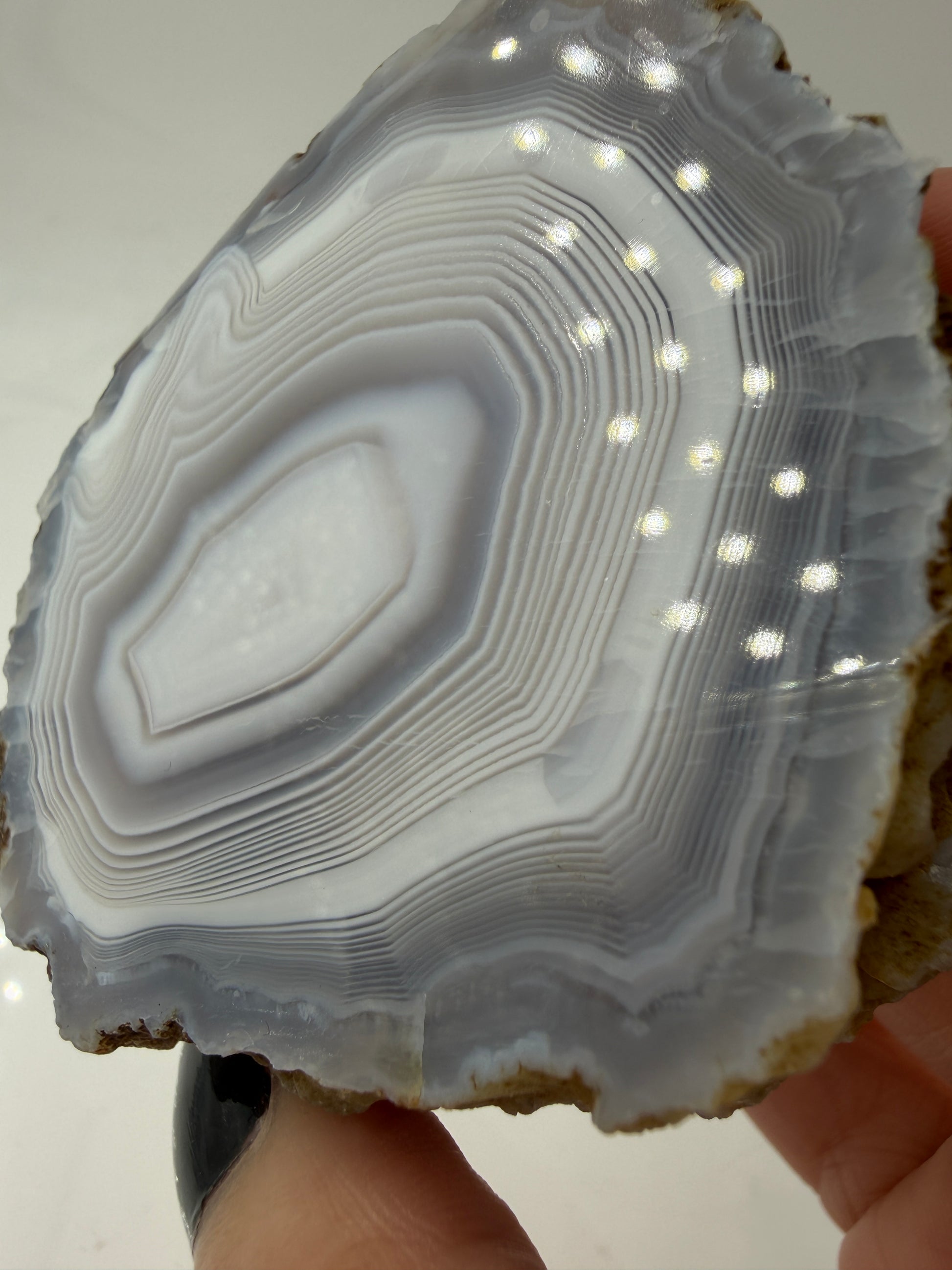 Nahaufnahme der Chalcedon-Bänderung eines marokkanischen Achats, zeigt mikro-kristalline Zuwachszonen und Quarz-Zentrum.
