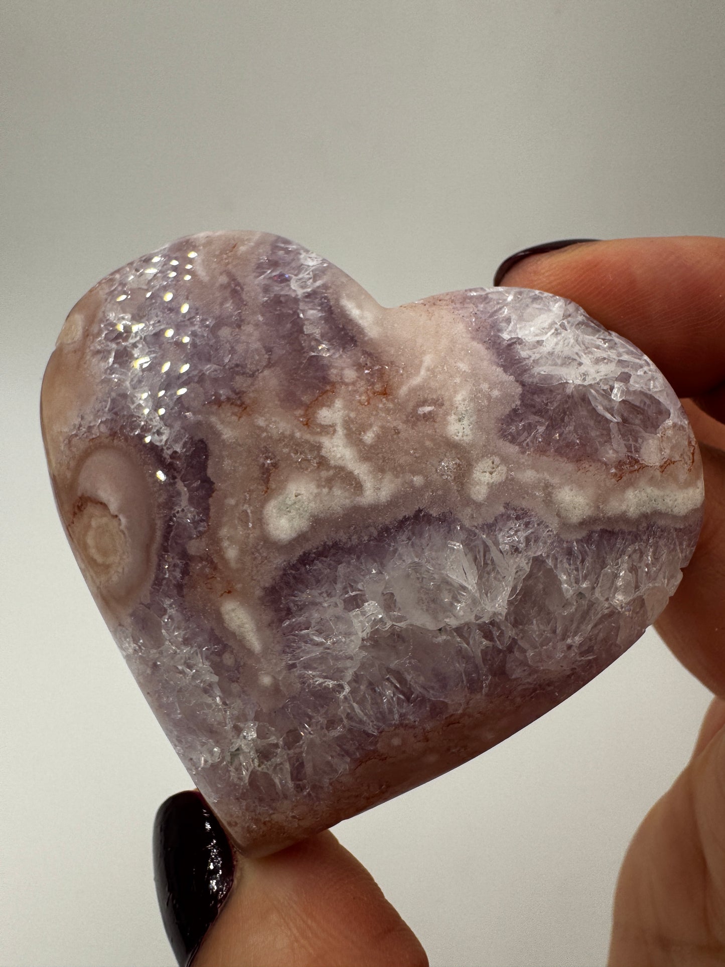 Herzförmiges Carving aus tiefviolettem Amethyst und Blumenachat mit dendritischen Einschlüssen.