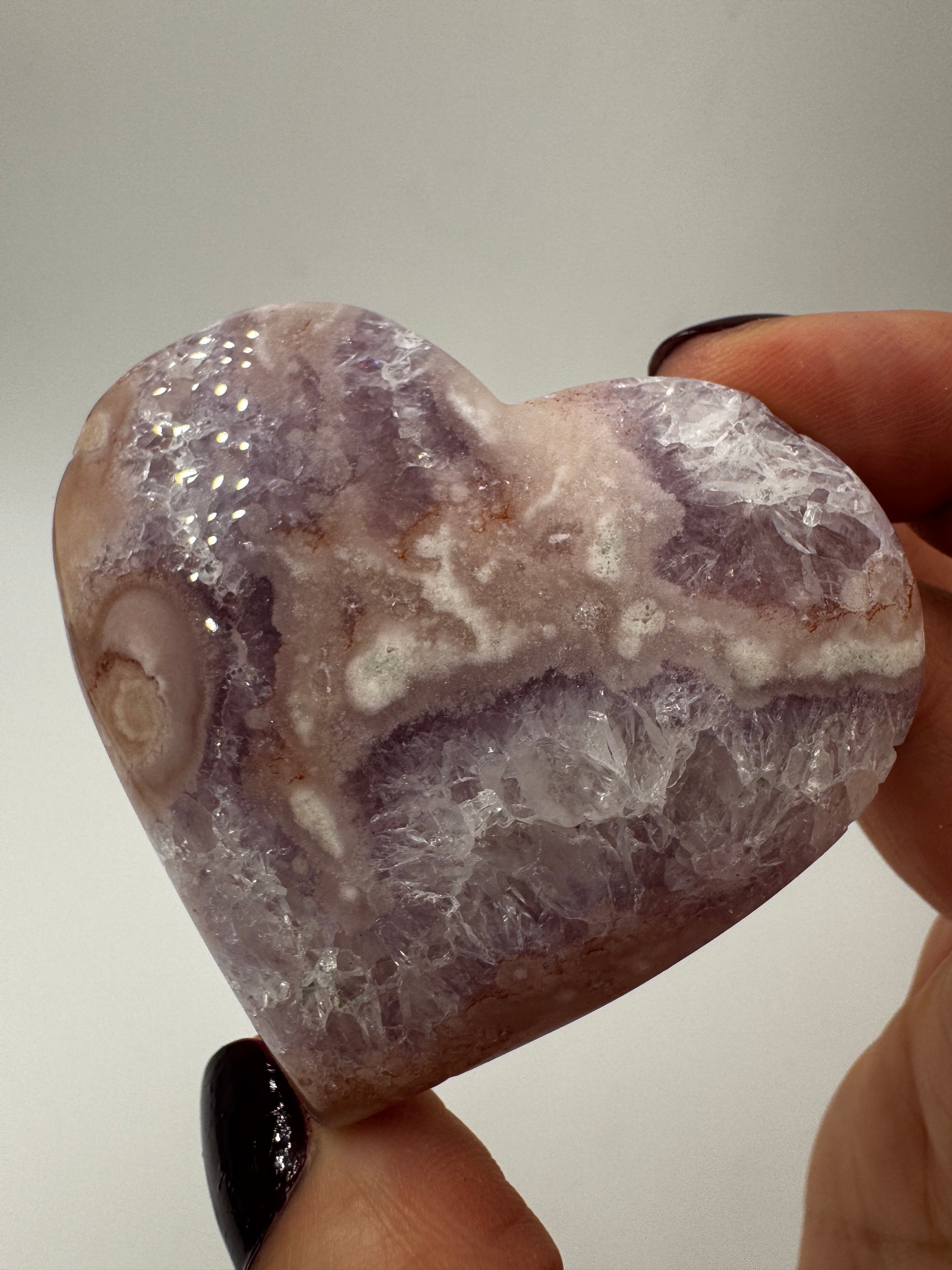 Herzförmiges Carving aus tiefviolettem Amethyst und Blumenachat mit dendritischen Einschlüssen.