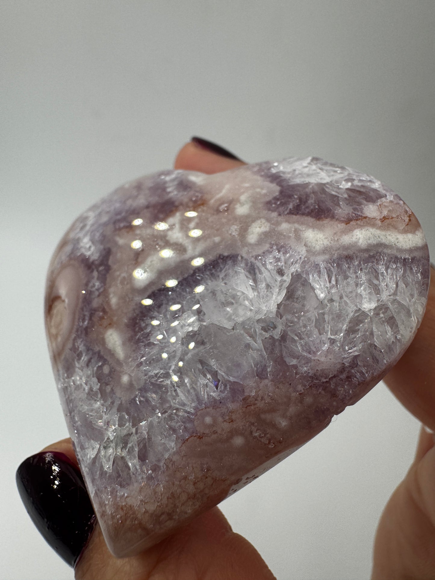 Herzförmiges Carving aus tiefviolettem Amethyst und Blumenachat mit dendritischen Einschlüssen.