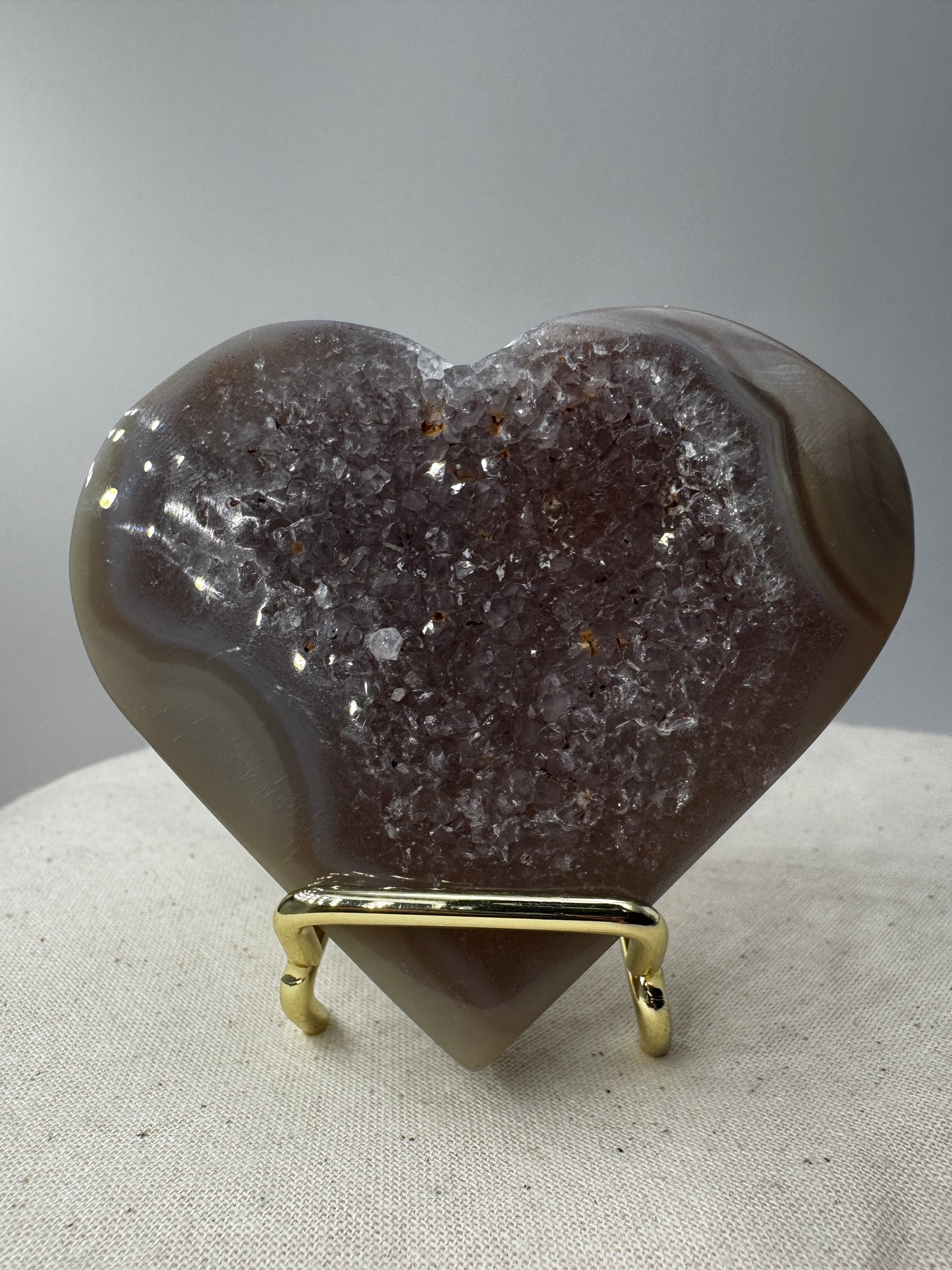 Herzförmiges Carving aus tiefviolettem Amethyst und gebändertem Achat.
