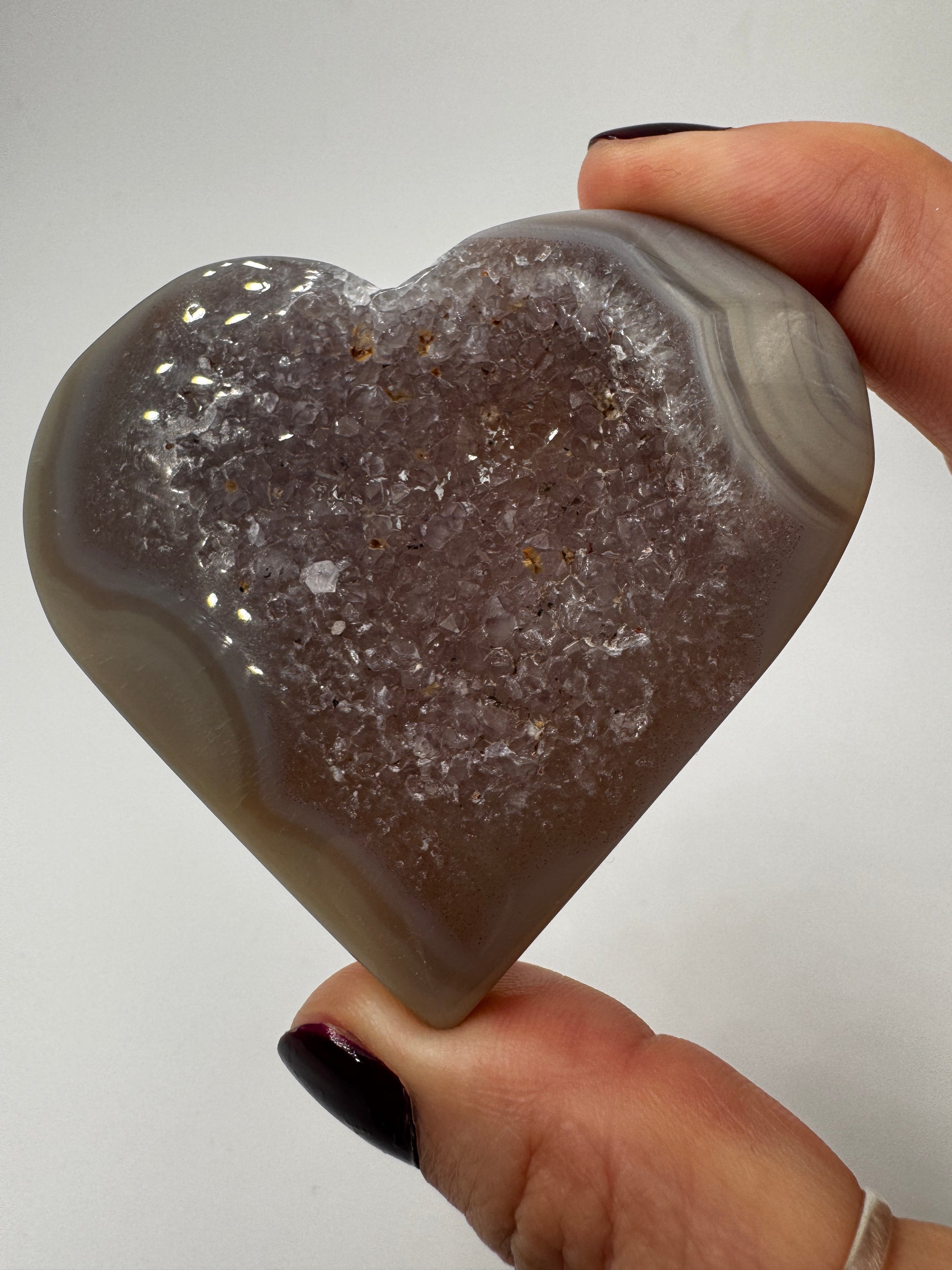 Herzförmiges Carving aus tiefviolettem Amethyst und gebändertem Achat.