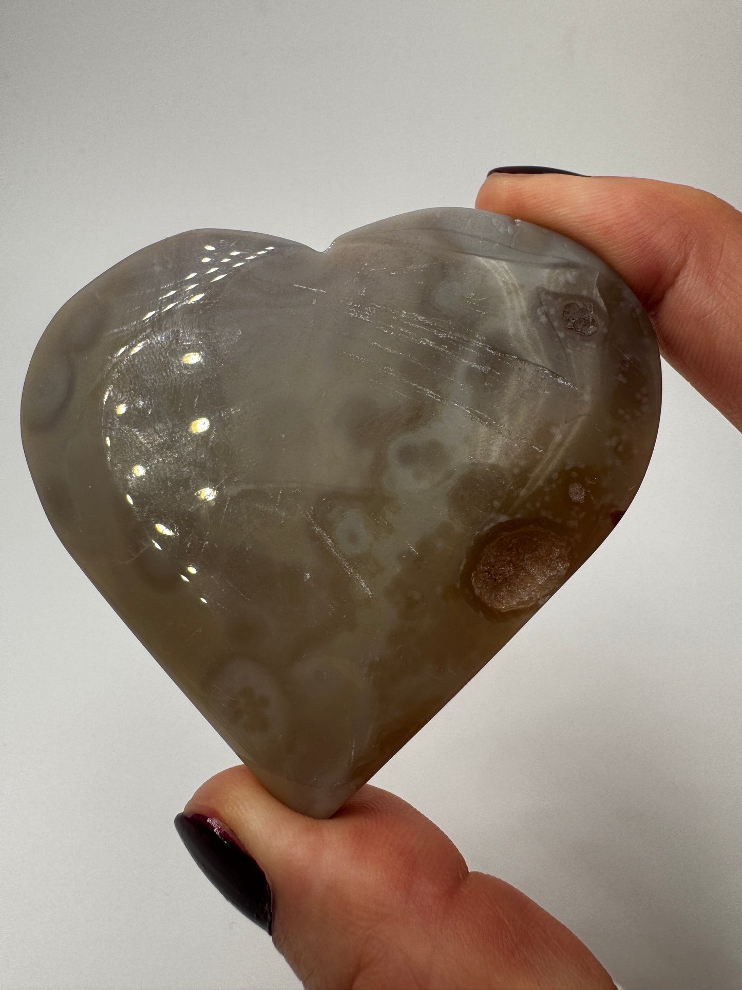 Herzförmiges Carving aus tiefviolettem Amethyst und gebändertem Achat.