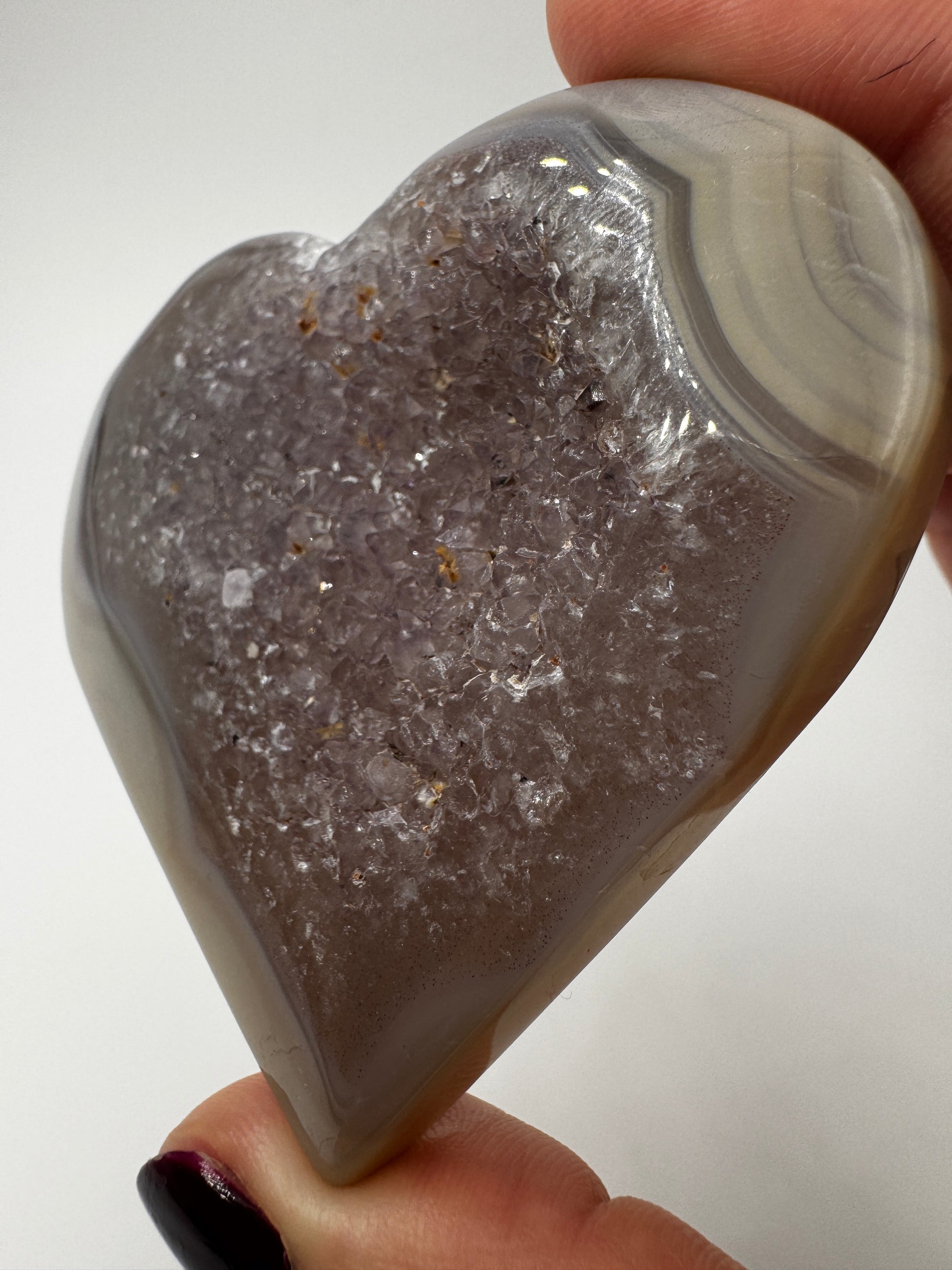 Herzförmiges Carving aus tiefviolettem Amethyst und gebändertem Achat.
