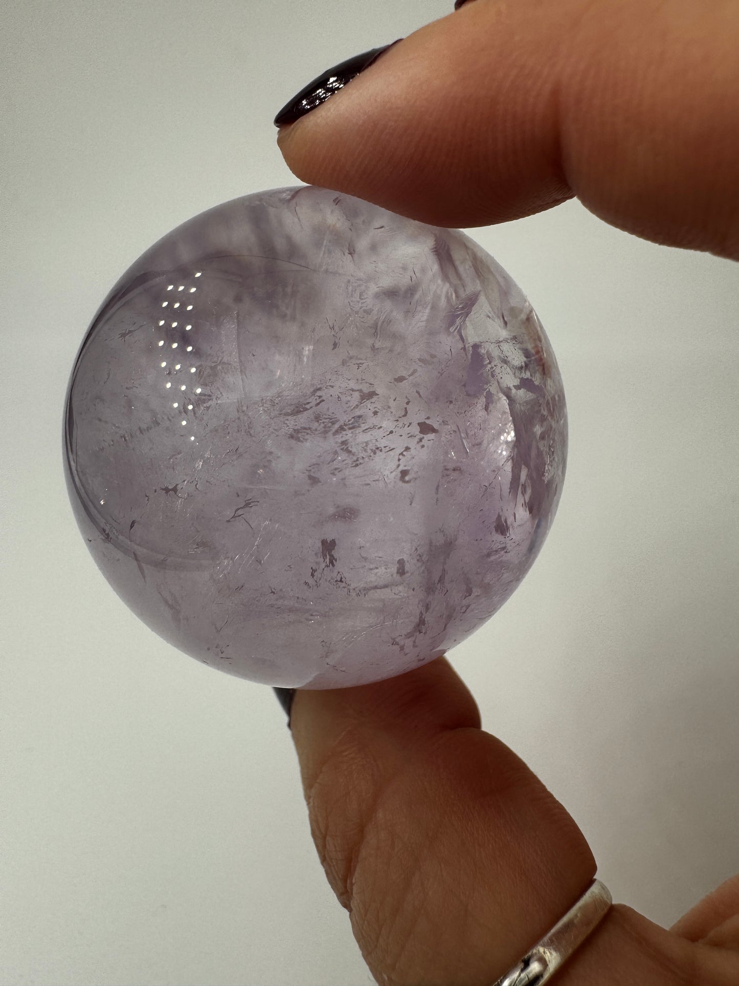 Handpolierte Amethyst-Kugel AK32 mit zartem Violett und feinen Zonarstrukturen.