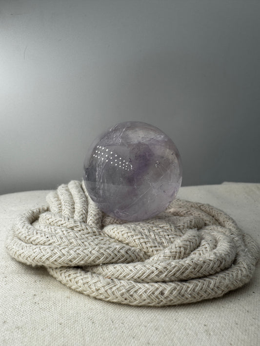 Handpolierte Amethyst-Kugel AKB32 mit zartem Violett und feinen Zonarstrukturen.