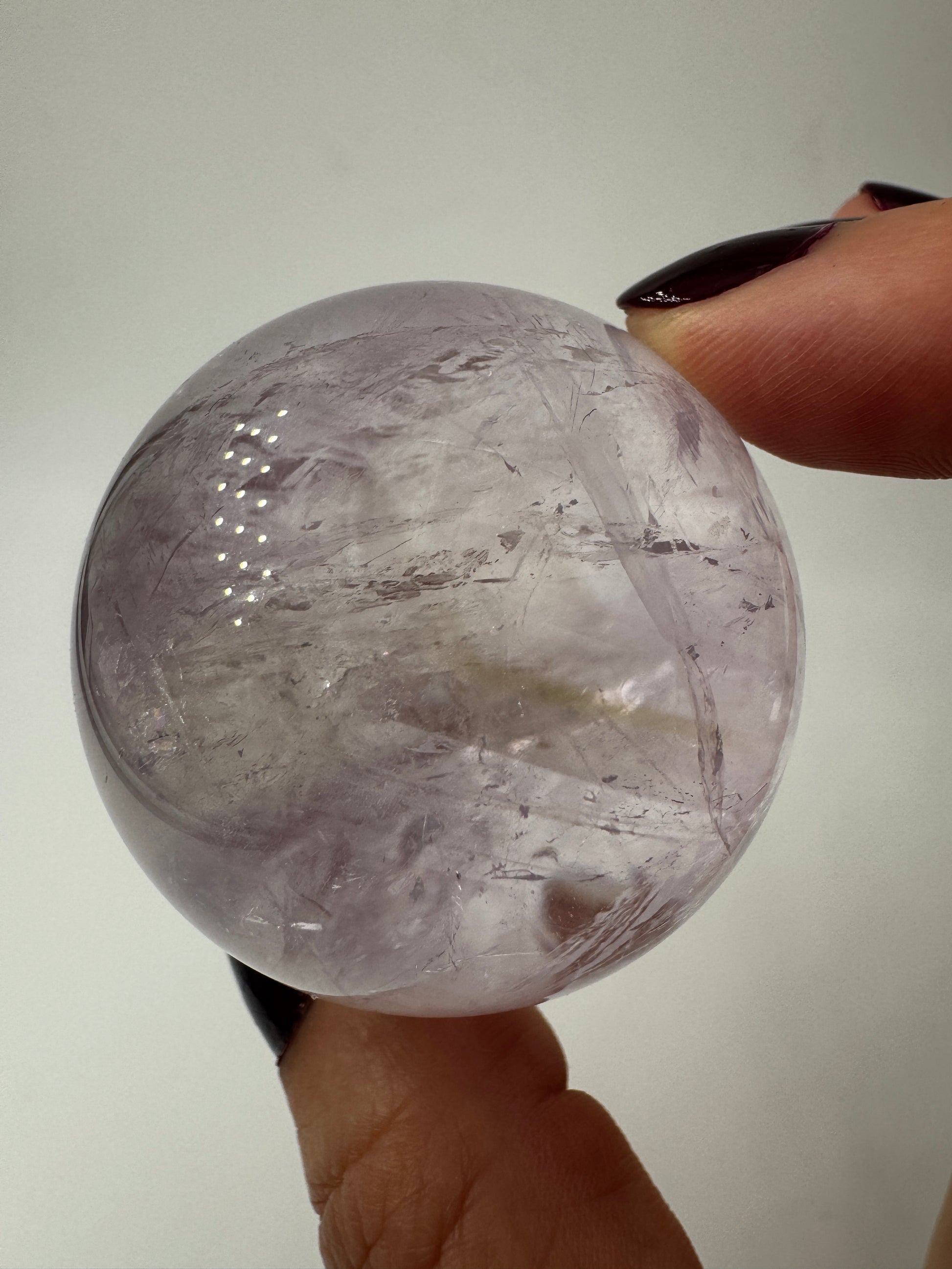 Handpolierte Amethyst-Kugel AKB32 mit zartem Violett und feinen Zonarstrukturen.