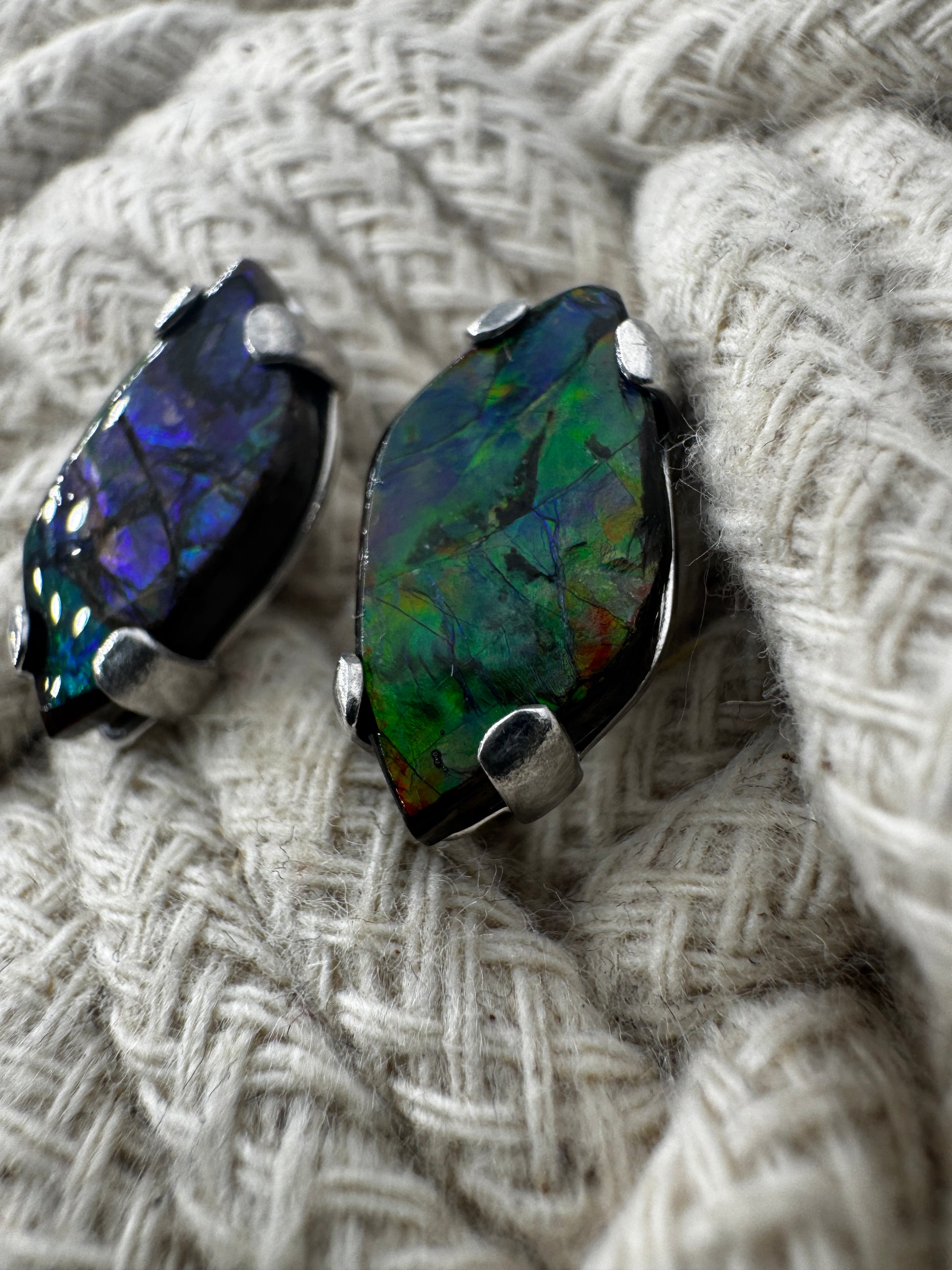 Ohrstecker aus Ammolith in Silberfassung, 1,8 × 1 cm, mit irisierendem Farbenspiel in  Grün und Blau.