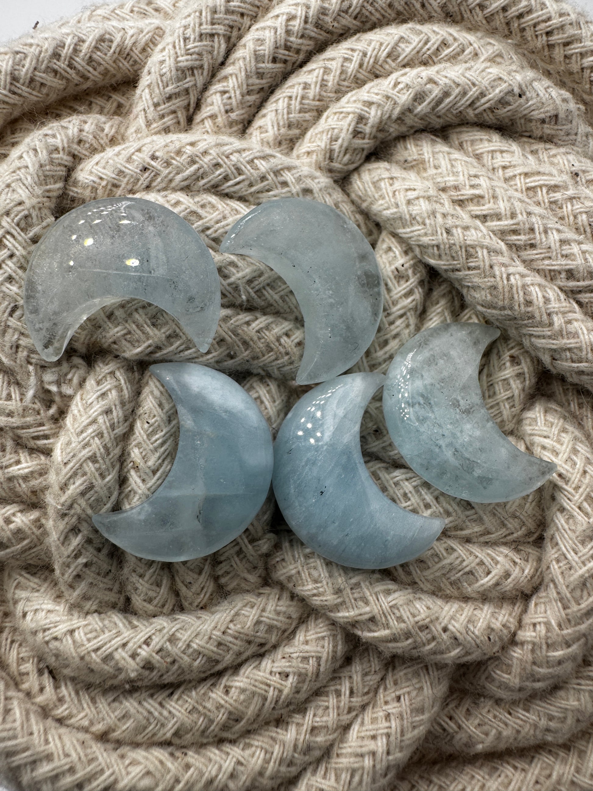 Handgefertigtes Carving aus Aquamarin in Mondform, helles eisenblaues Beryll-Mineral mit natürlicher Transparenz.