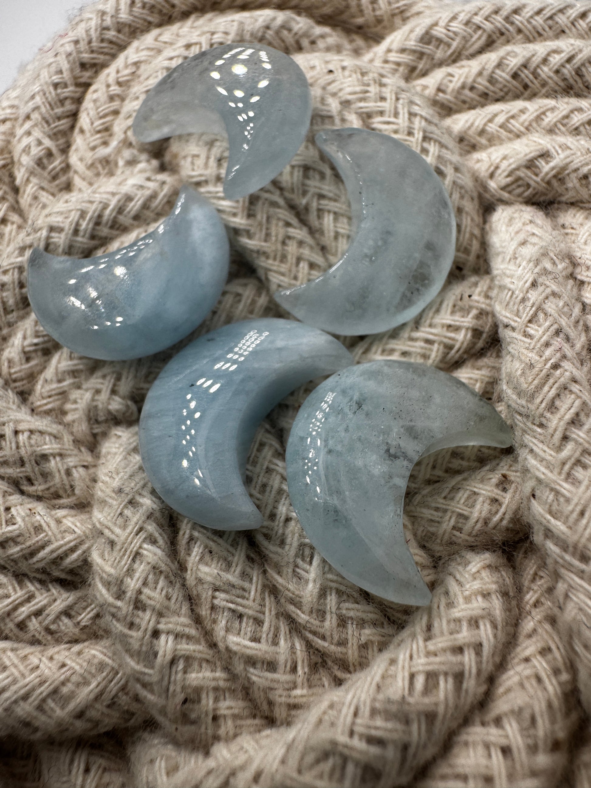 Handgefertigtes Carving aus Aquamarin in Mondform, helles eisenblaues Beryll-Mineral mit natürlicher Transparenz.
