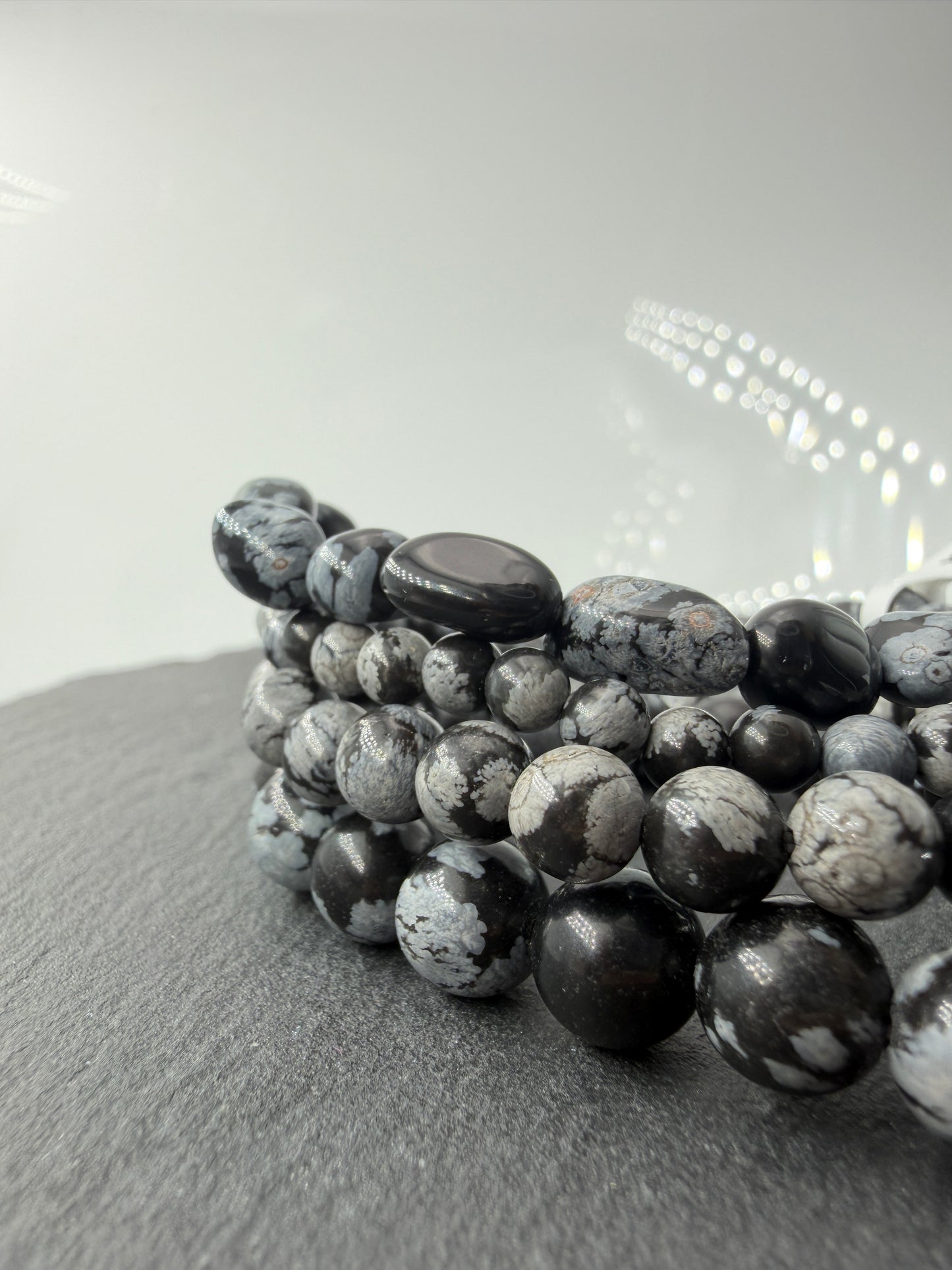 Kugelarmband aus Schneeflocken-Obsidian mit markanten weißen Cristobalit-Einschlüssen auf schwarzem Grund.