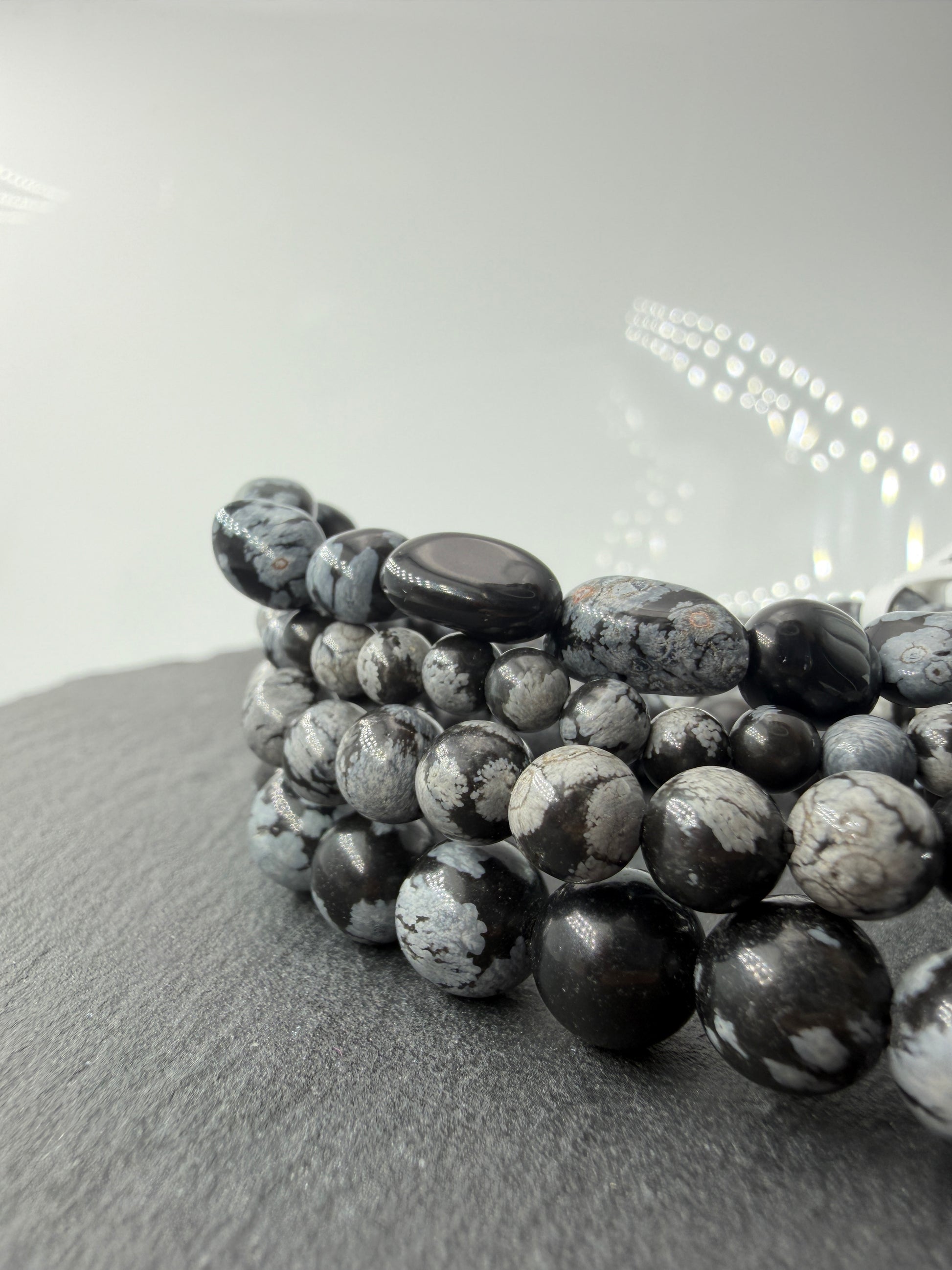 Kugelarmband aus Schneeflocken-Obsidian mit markanten weißen Cristobalit-Einschlüssen auf schwarzem Grund.