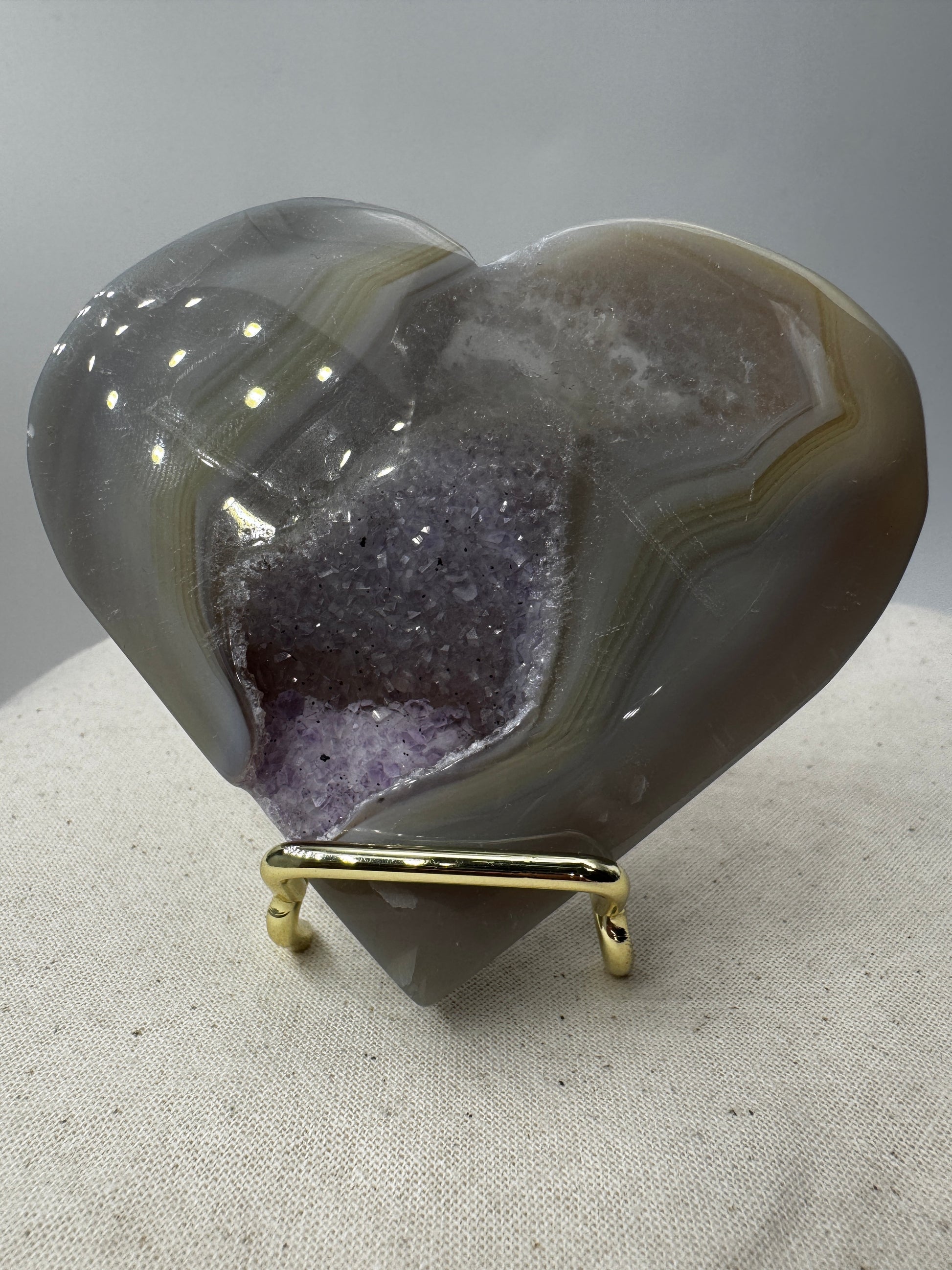 Großformatiges herzförmiges Carving aus violettem Amethyst und gebändertem Achat, B-Ware mit seitlicher Beschädigung.
