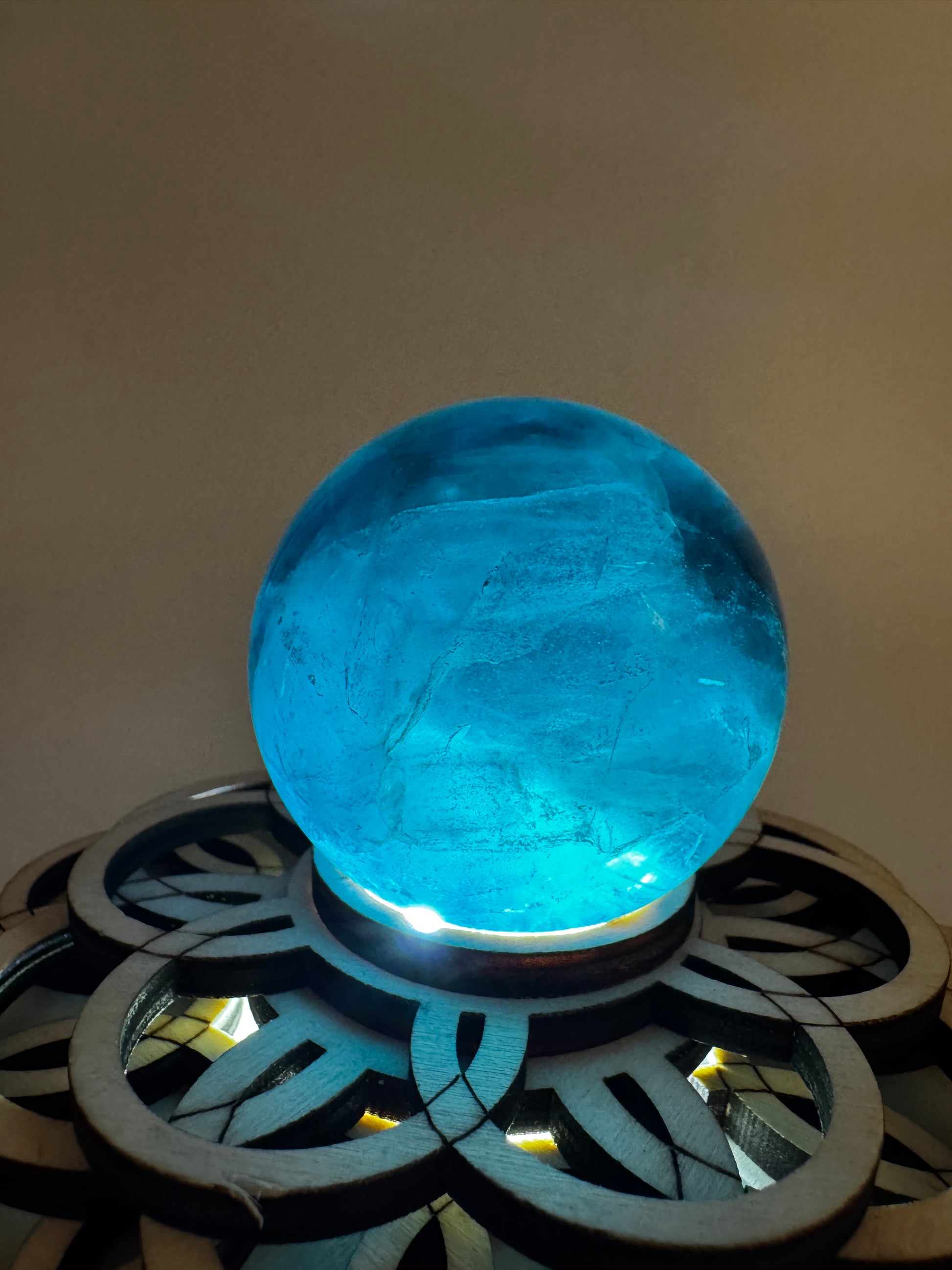 Eine tiefblaue, polierte Fluorit-Kugel mit inneren Wachstumsstrukturen und einem minimalen, authentischen Oberflächenmerkmal.