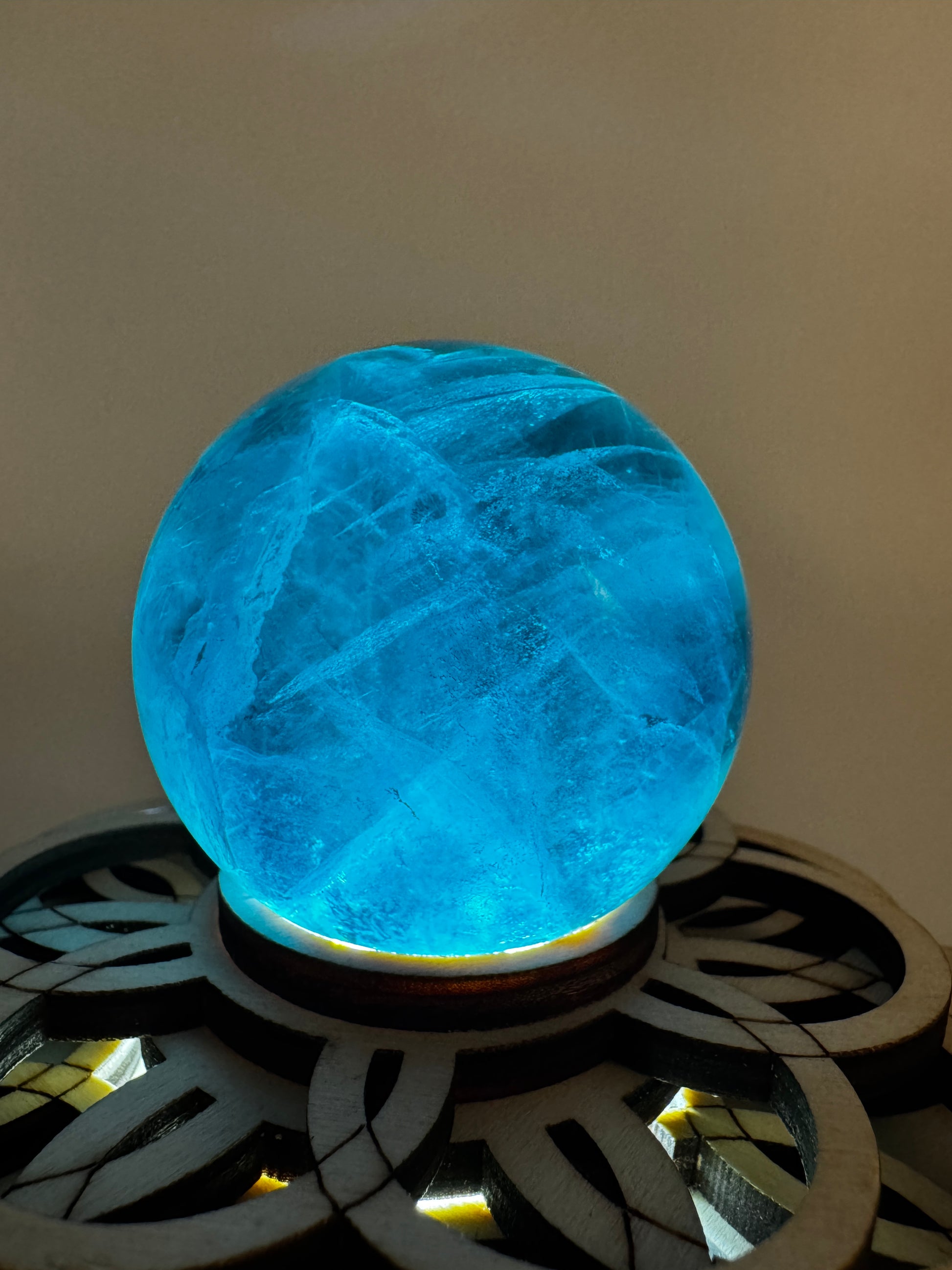 Eine tiefblaue, polierte Fluorit-Kugel mit inneren Wachstumsstrukturen und einem minimalen, authentischen Oberflächenmerkmal.