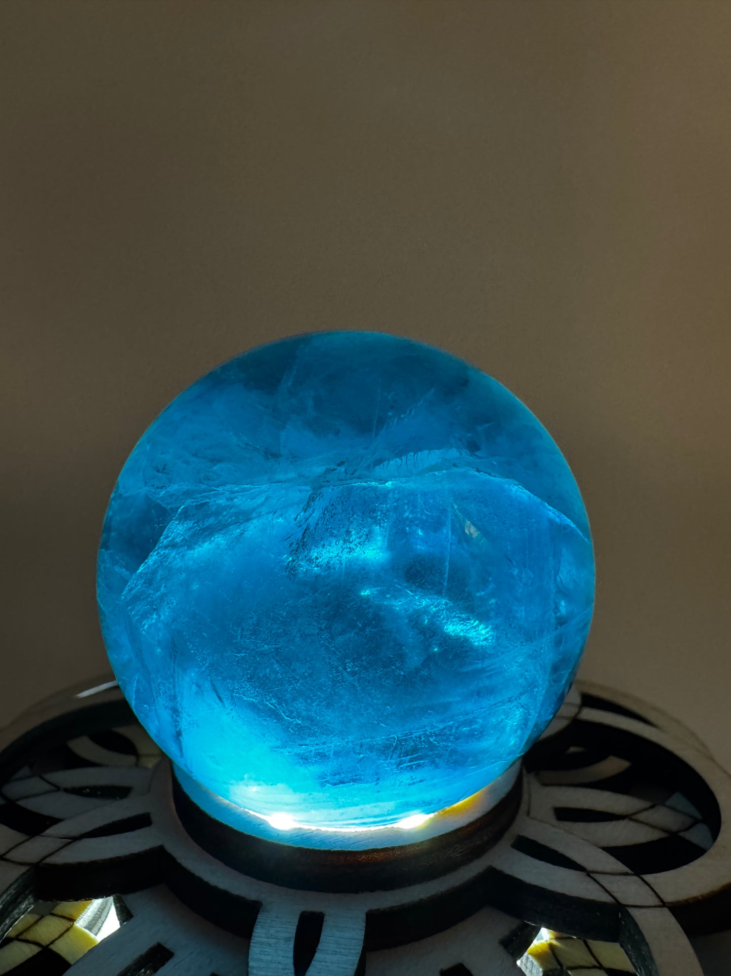 Eine tiefblaue, polierte Fluorit-Kugel mit inneren Wachstumsstrukturen und einem minimalen, authentischen Oberflächenmerkmal.