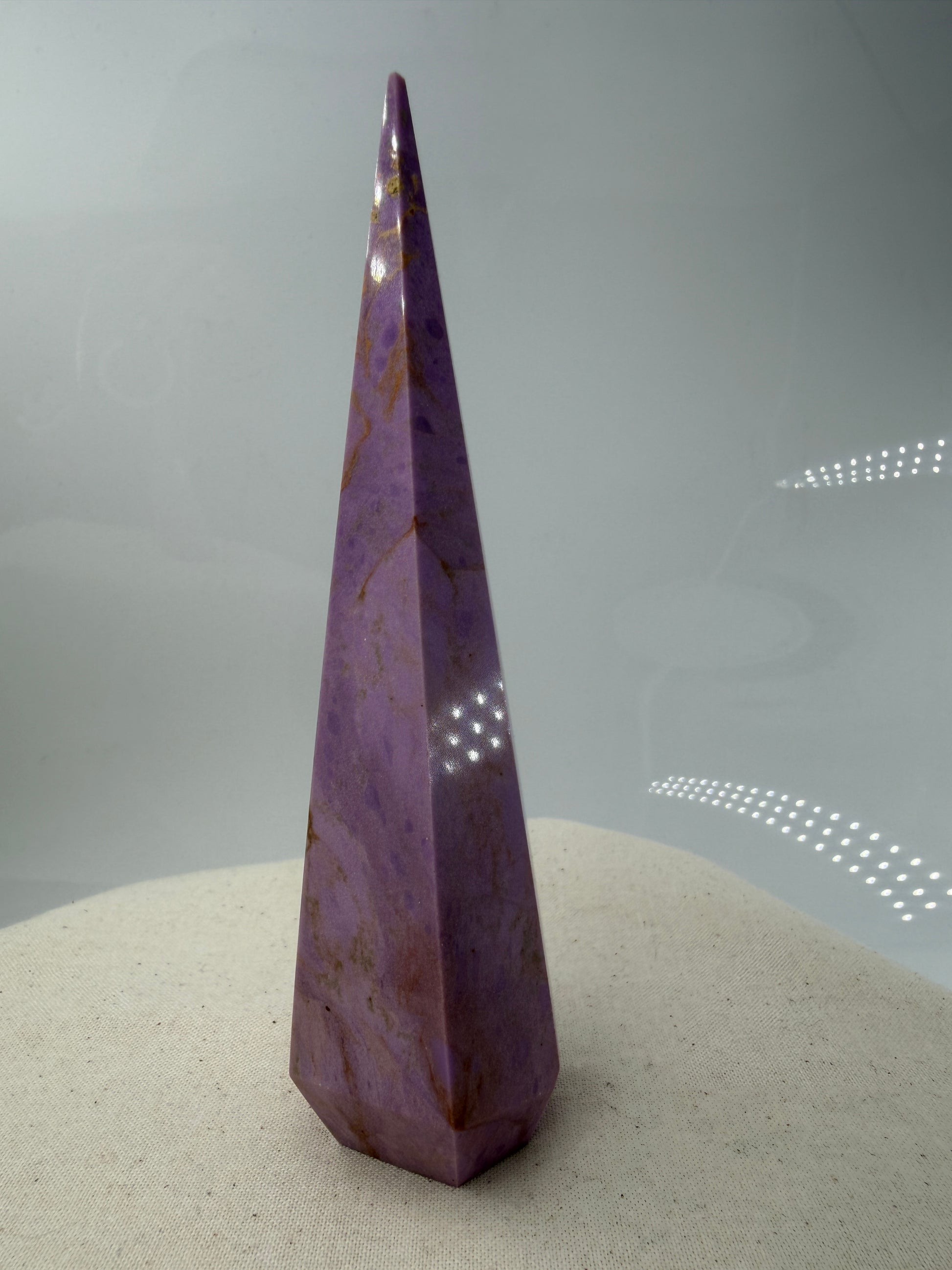 Eine fliederfarbene Phosphosiderit-Stele mit deutlich sichtbarer, natürlicher Bruchstelle an der Spitze und gelben Mineraladern.