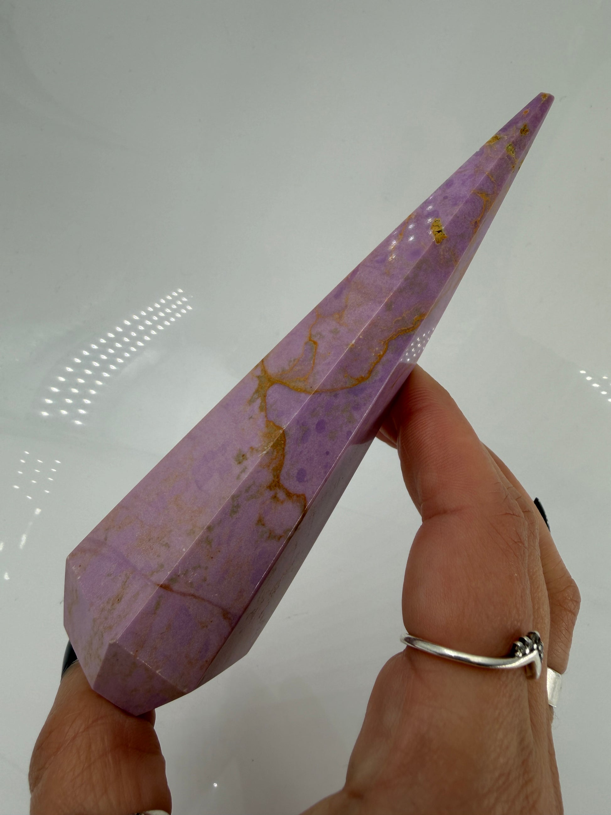 Eine fliederfarbene Phosphosiderit-Stele mit deutlich sichtbarer, natürlicher Bruchstelle an der Spitze und gelben Mineraladern.