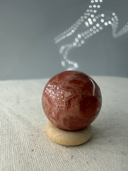 Polierte Kugel aus Rhodochrosit mit leuchtend rosa konzentrischen Bändern, Durchmesser 1,7 cm, B-Ware mit kleinen Macken.