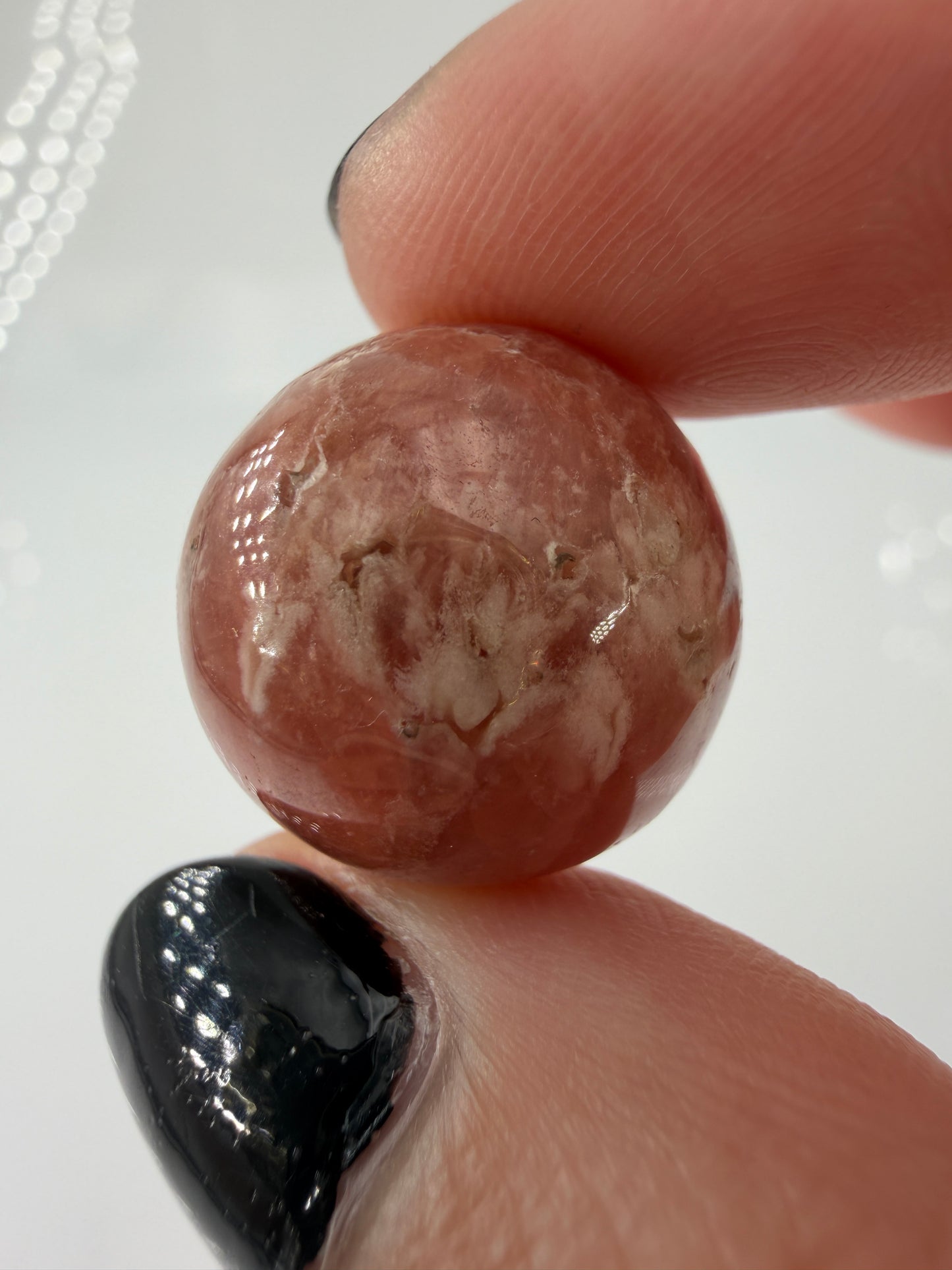 Polierte Kugel aus Rhodochrosit mit leuchtend rosa konzentrischen Bändern, Durchmesser 1,7 cm, B-Ware mit kleinen Macken.