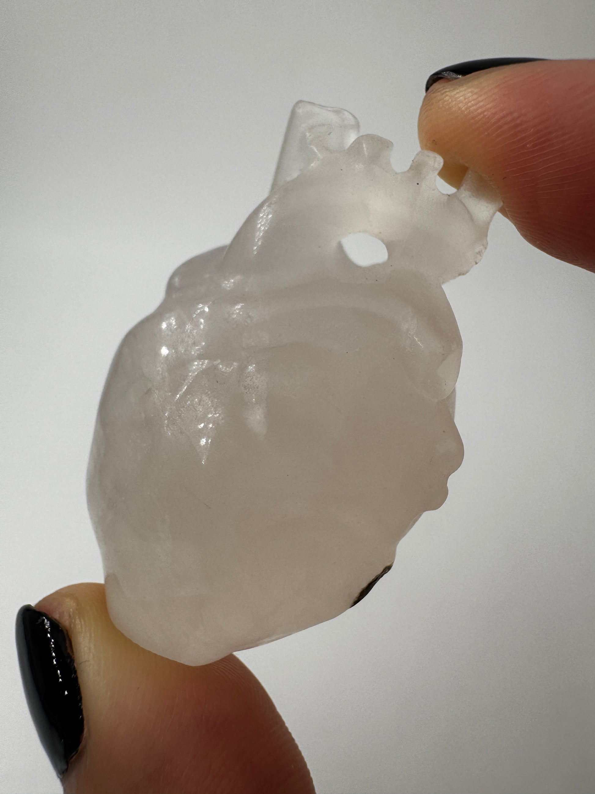 Anatomisches Herz aus Bergkristall mit einer kleinen Stelle aus Muttergestein.