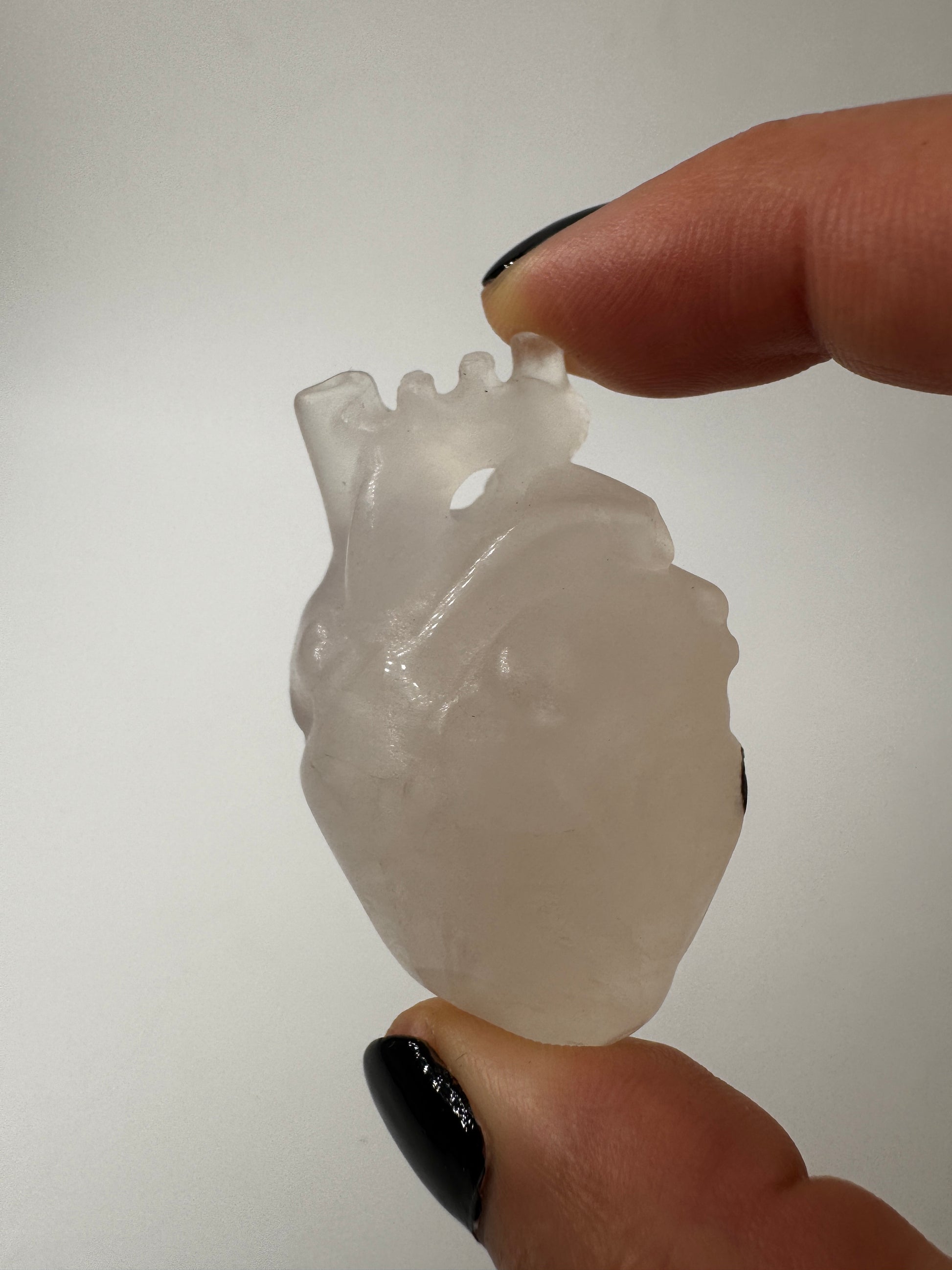 Anatomisches Herz aus Bergkristall mit einer kleinen Stelle aus Muttergestein.