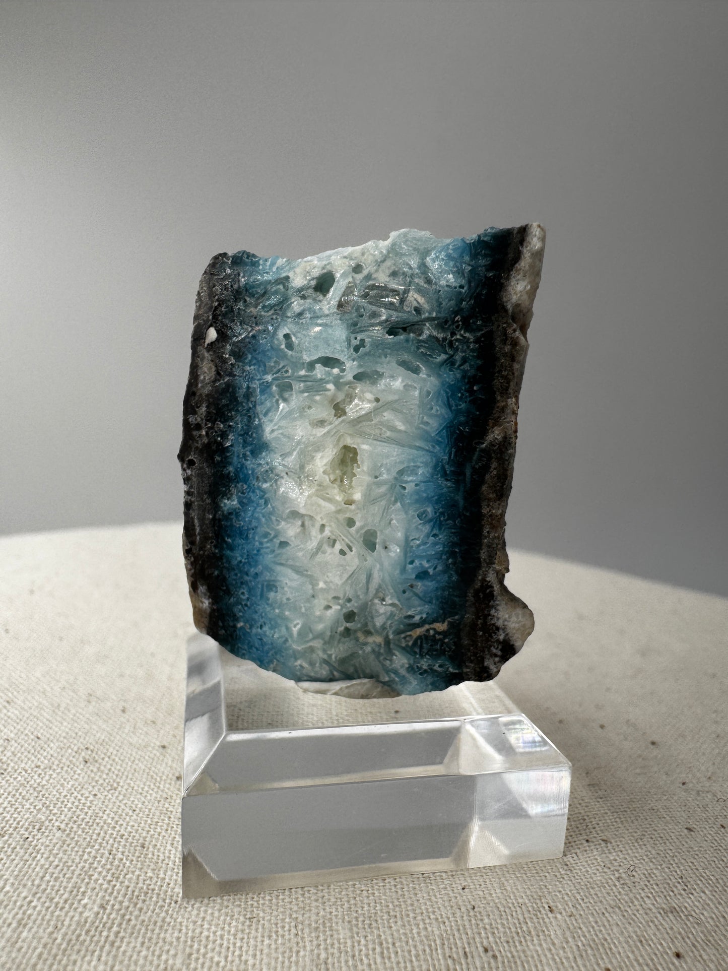 Eine Scheibe aus  Blue Ice Glacierite  mit polierter Oberfläche und charakteristischen Farbe von weiß, blau und schwarz. 
