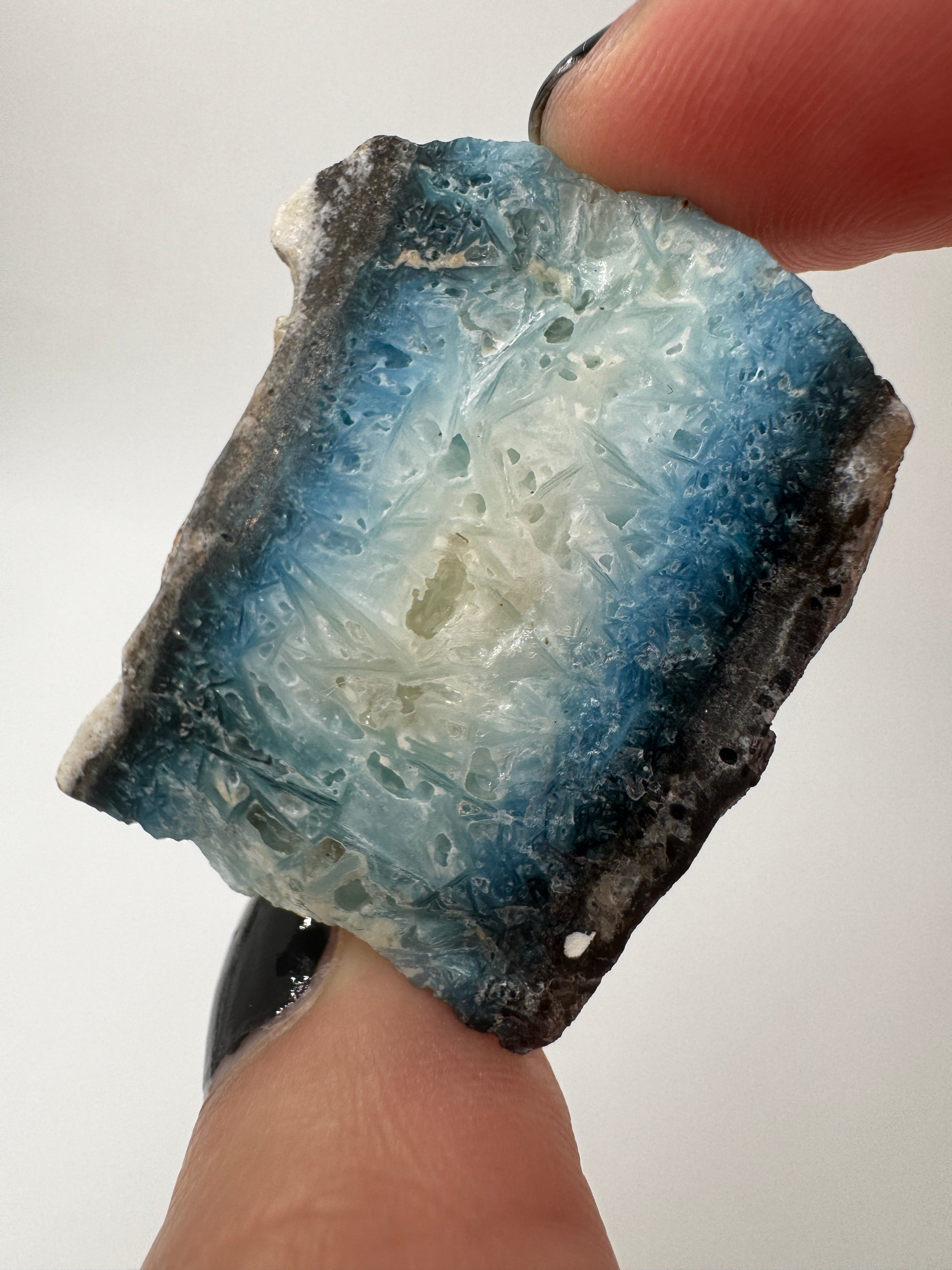 Eine Scheibe aus  Blue Ice Glacierite  mit polierter Oberfläche und charakteristischen Farbe von weiß, blau und schwarz. 