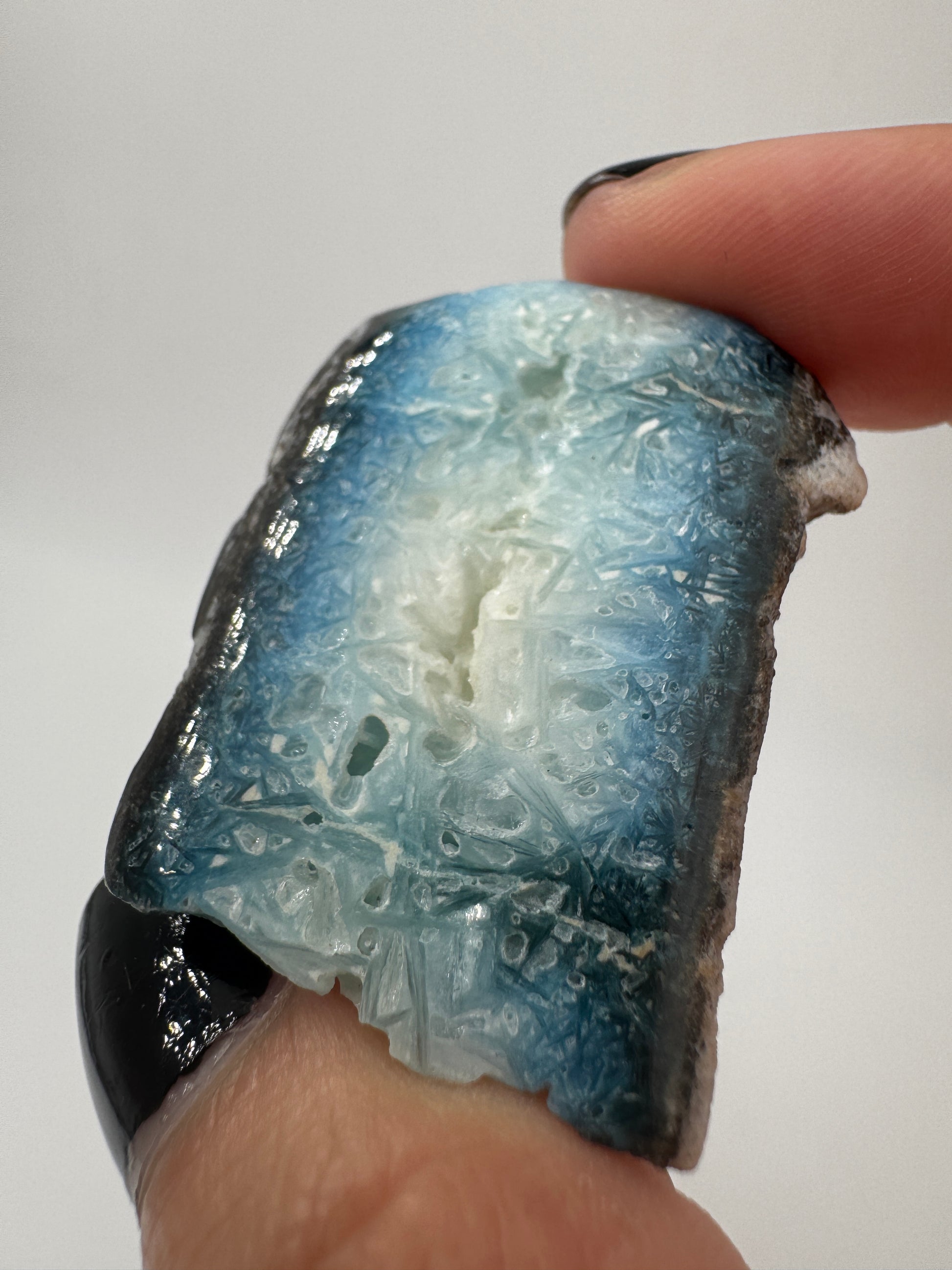 Eine Scheibe aus  Blue Ice Glacierite  mit polierter Oberfläche und charakteristischen Farbe von weiß, blau und schwarz. 