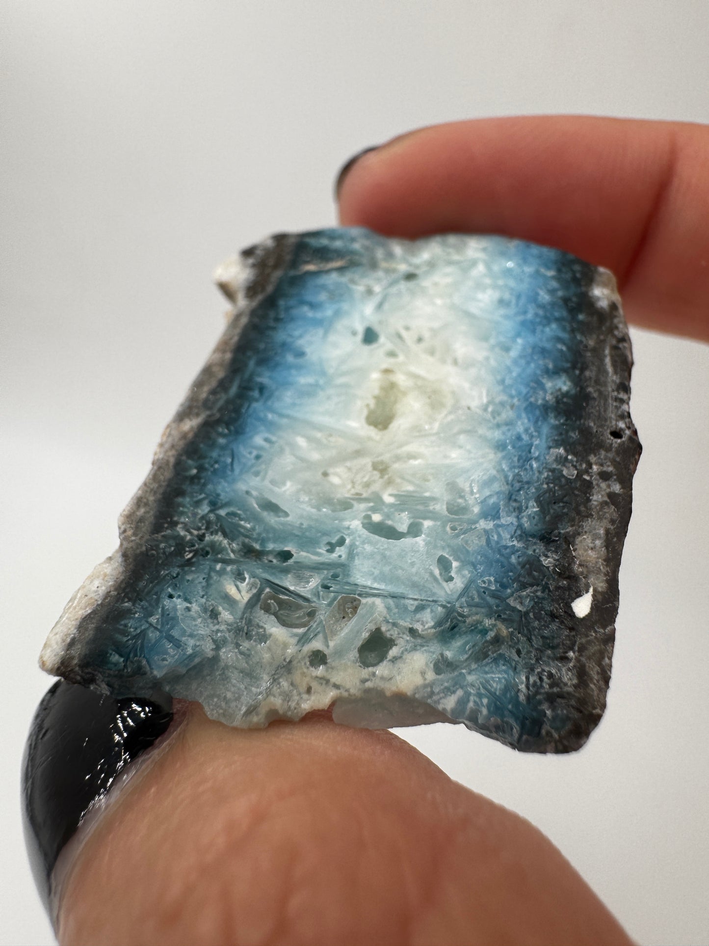 Eine Scheibe aus  Blue Ice Glacierite  mit polierter Oberfläche und charakteristischen Farbe von weiß, blau und schwarz. 