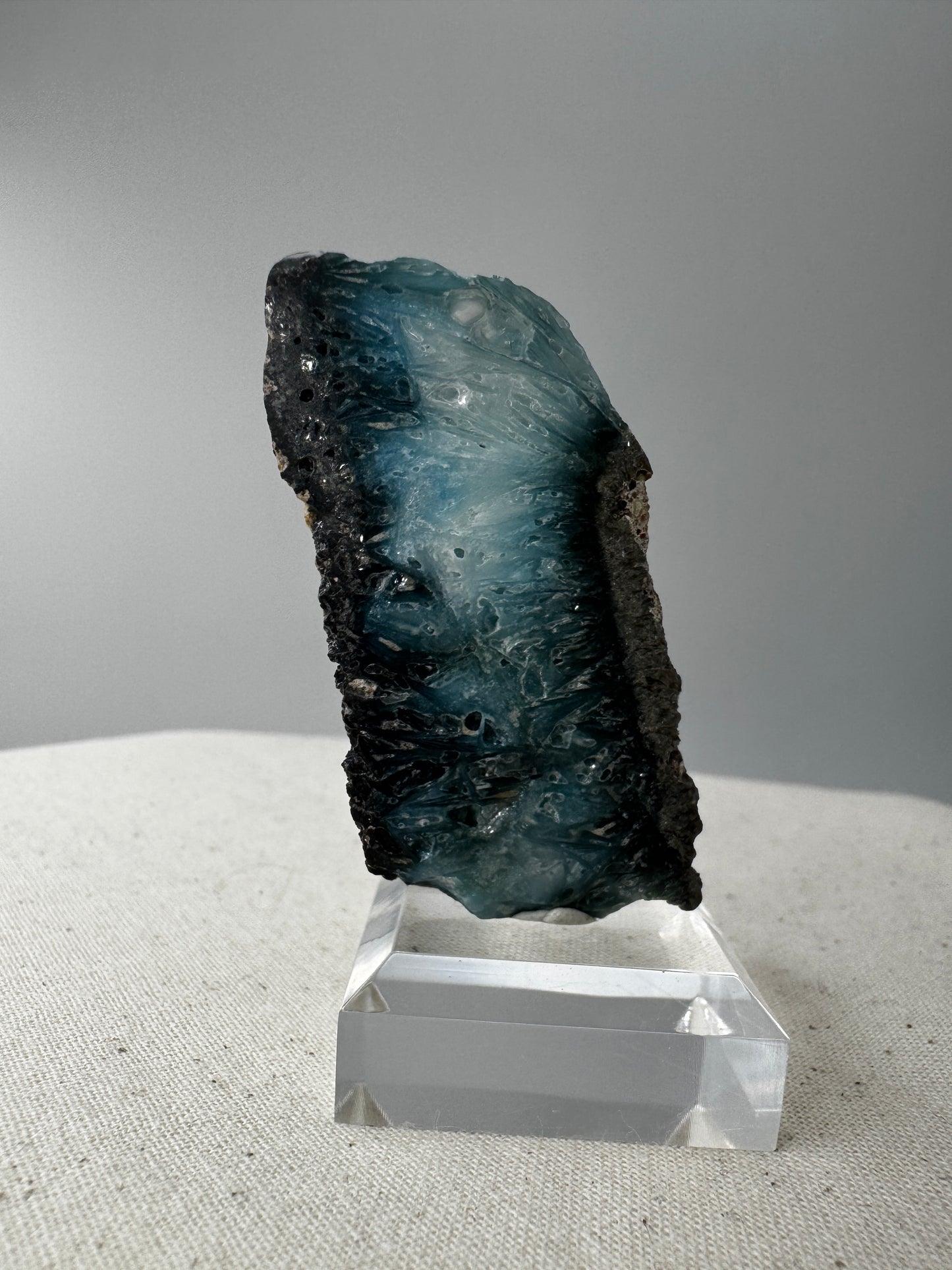 Eine Scheibe aus  Blue Ice Glacierite  mit polierter Oberfläche und charakteristischen Farbe von weiß, blau und schwarz. 