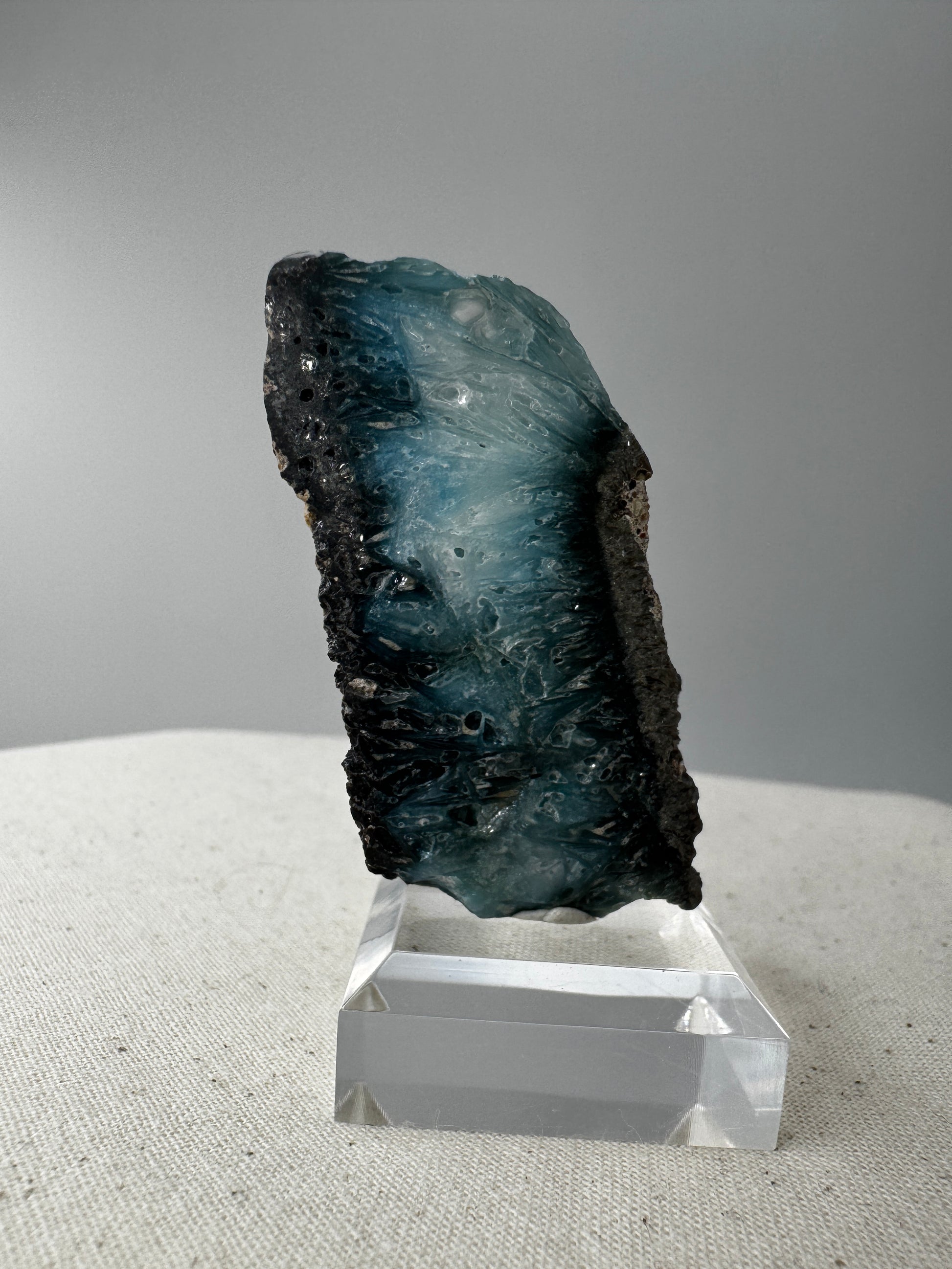 Eine Scheibe aus  Blue Ice Glacierite  mit polierter Oberfläche und charakteristischen Farbe von weiß, blau und schwarz. 