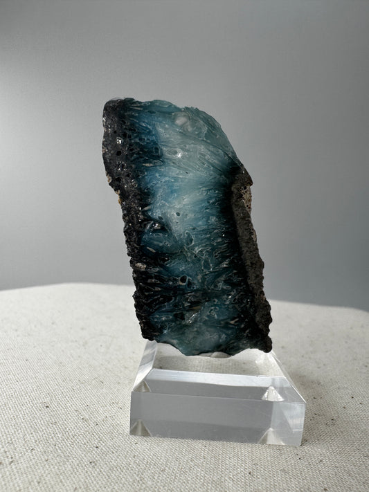 Eine Scheibe aus  Blue Ice Glacierite  mit polierter Oberfläche und charakteristischen Farbe von weiß, blau und schwarz. 