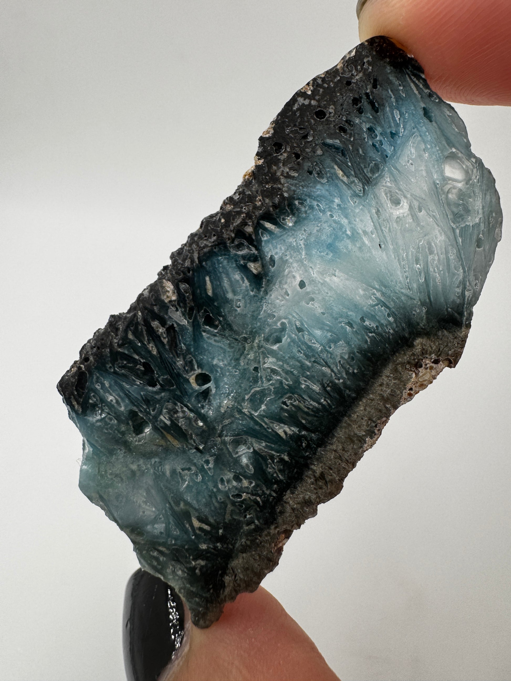 Eine Scheibe aus  Blue Ice Glacierite  mit polierter Oberfläche und charakteristischen Farbe von weiß, blau und schwarz. 