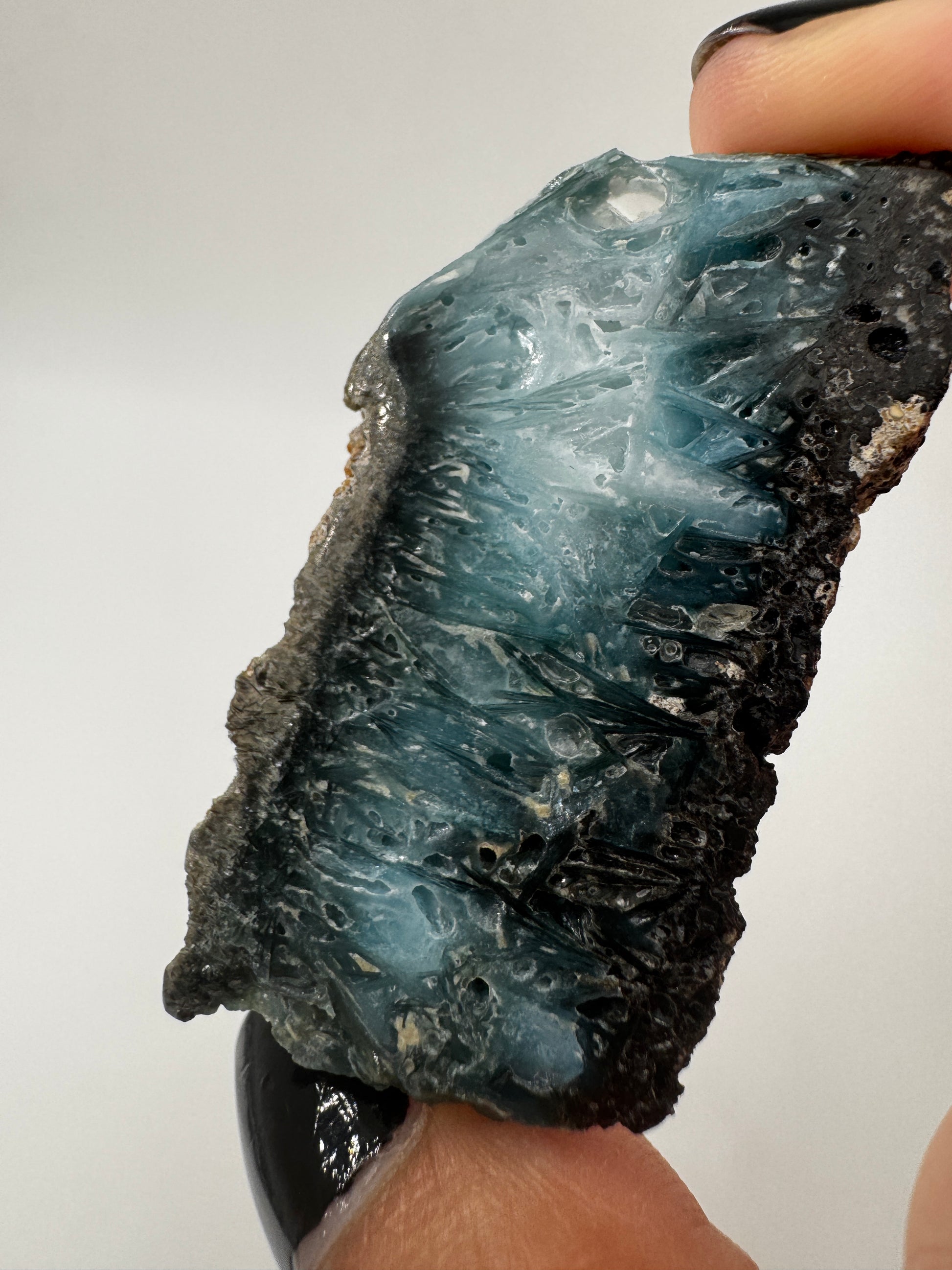 Eine Scheibe aus  Blue Ice Glacierite  mit polierter Oberfläche und charakteristischen Farbe von weiß, blau und schwarz. 