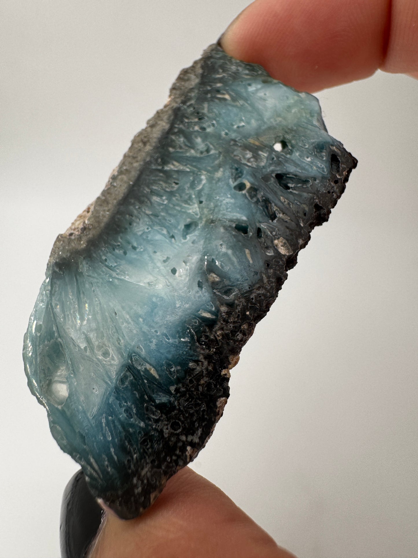 Eine Scheibe aus  Blue Ice Glacierite  mit polierter Oberfläche und charakteristischen Farbe von weiß, blau und schwarz. 