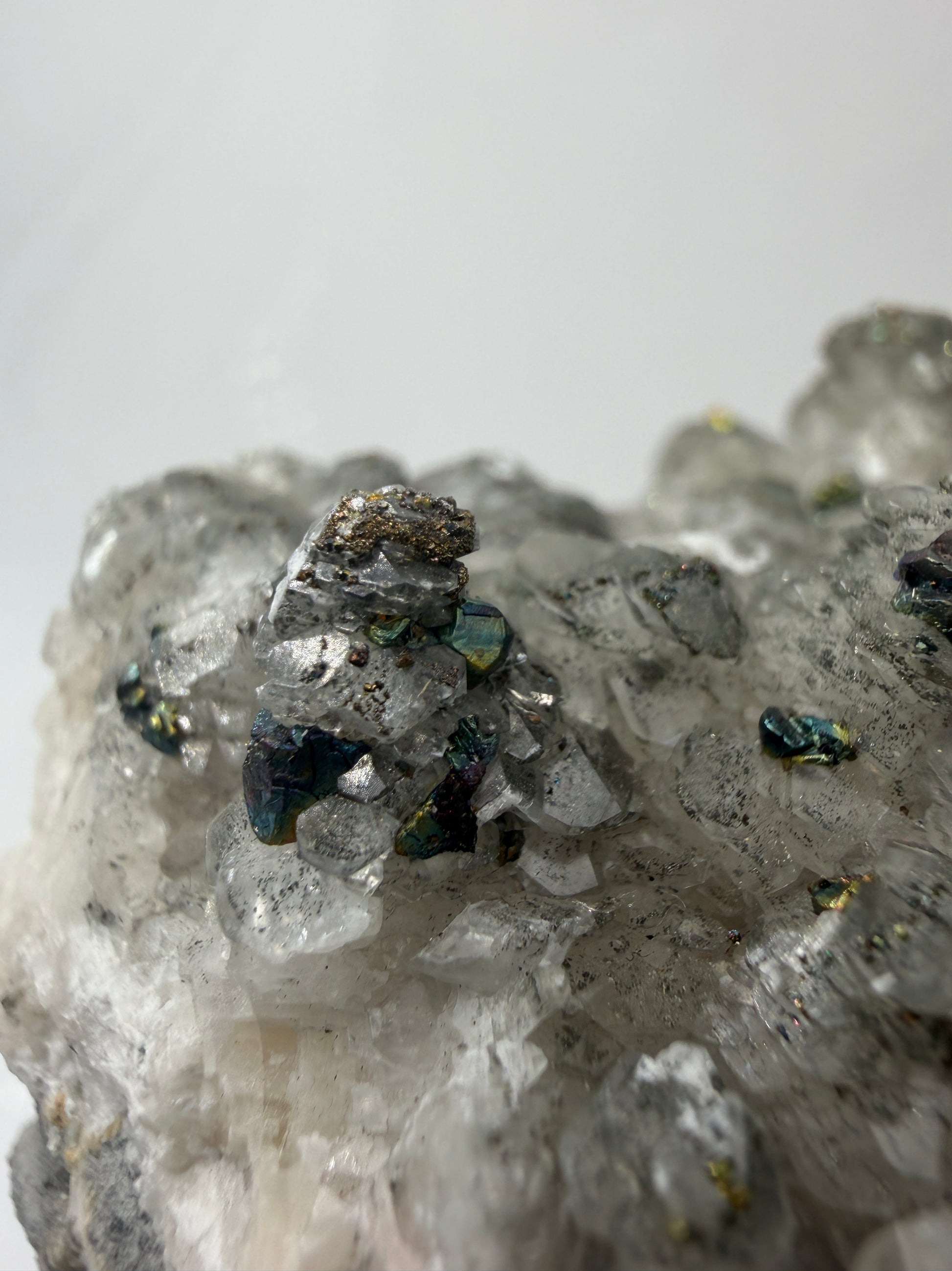 Weißer Calcit mit goldglänzenden Pyrit-Kristallen auf Gesteinsmatrix aus Herdringen, Sauerland.