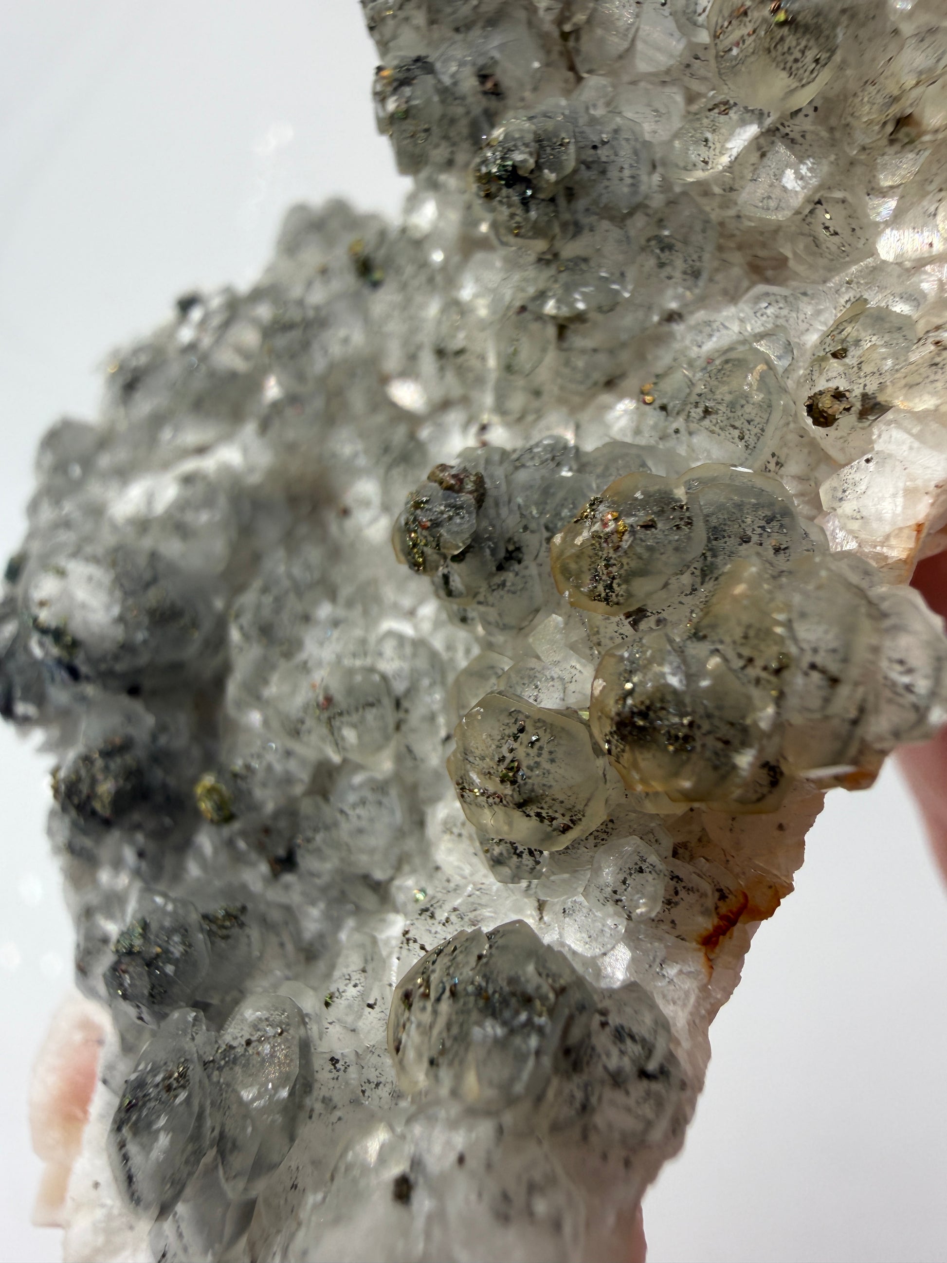 Weißer Calcit mit goldglänzenden Pyrit-Kristallen auf Gesteinsmatrix aus Herdringen, Sauerland.