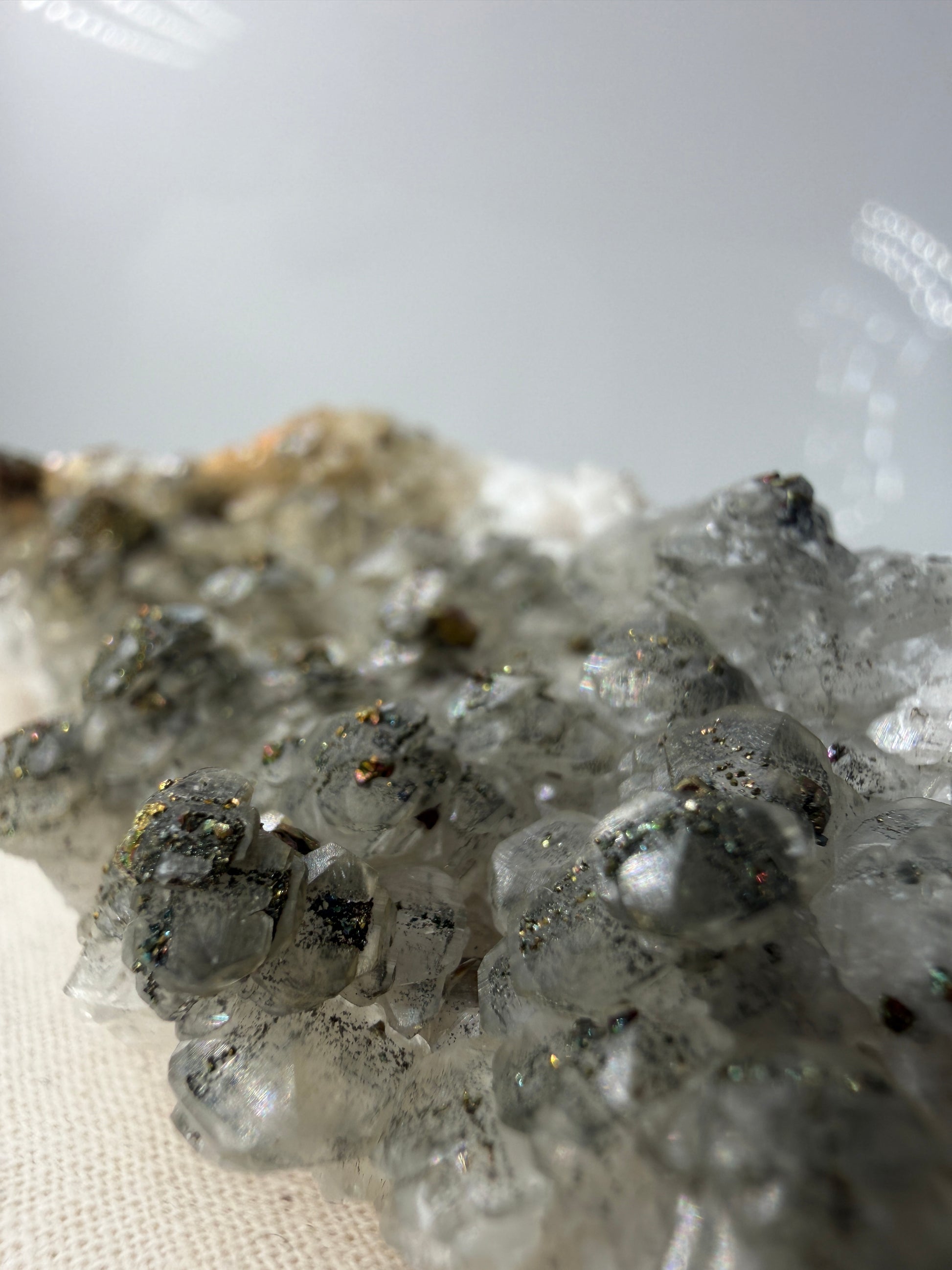 Weißer Calcit mit goldglänzenden Pyrit-Kristallen auf Gesteinsmatrix aus Herdringen, Sauerland.