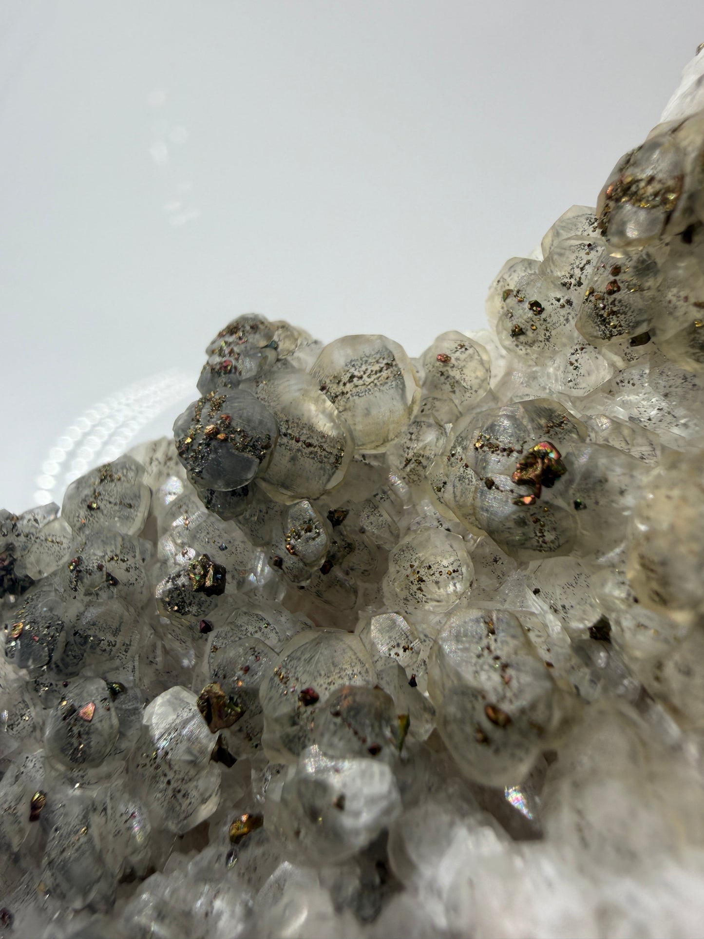 Weißer Calcit mit goldglänzenden Pyrit-Kristallen auf Gesteinsmatrix aus Herdringen, Sauerland.